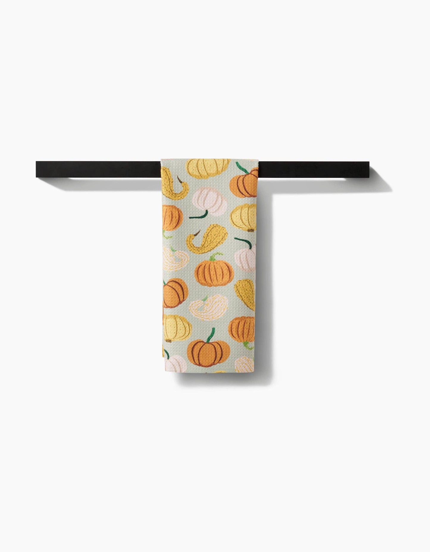Towel rack with a towel featuring pumpkins hanging on a white background