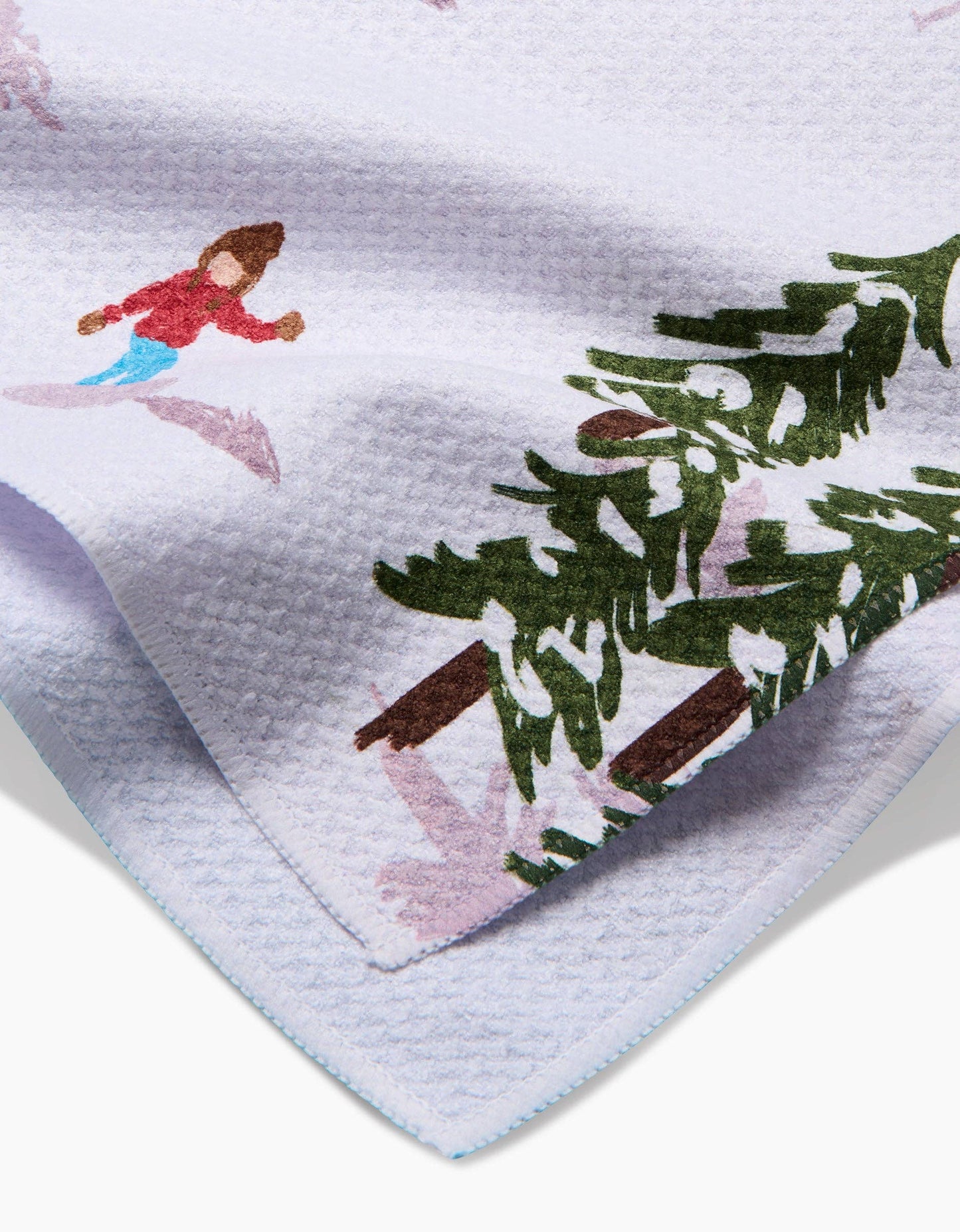 Children's towel with winter scene design featuring a child skiing and a Christmas tree.
