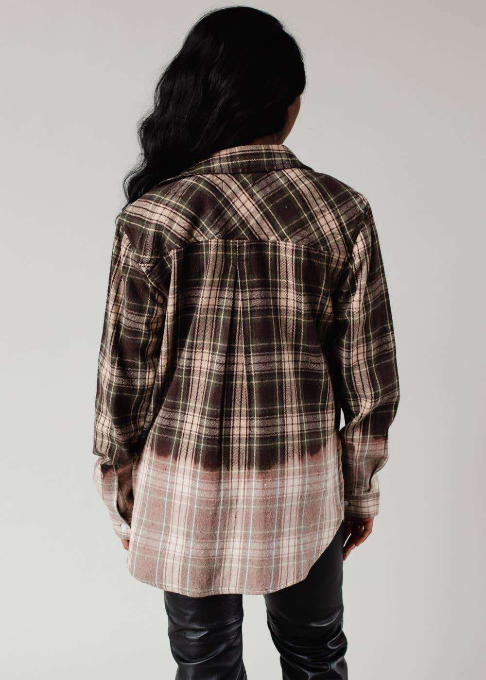Person wearing a plaid shirt with a neutral background