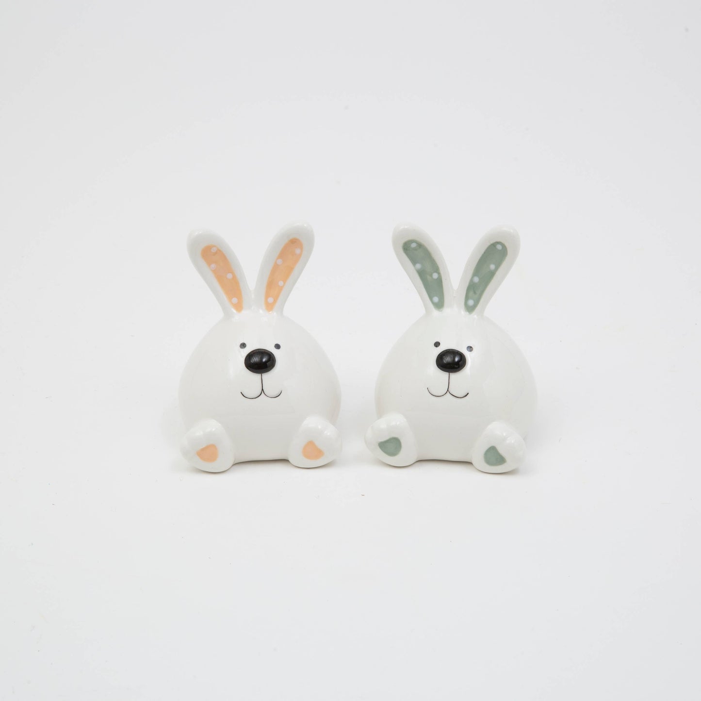 Two cartoon-style rabbit figurines with colored ears on a light gray background