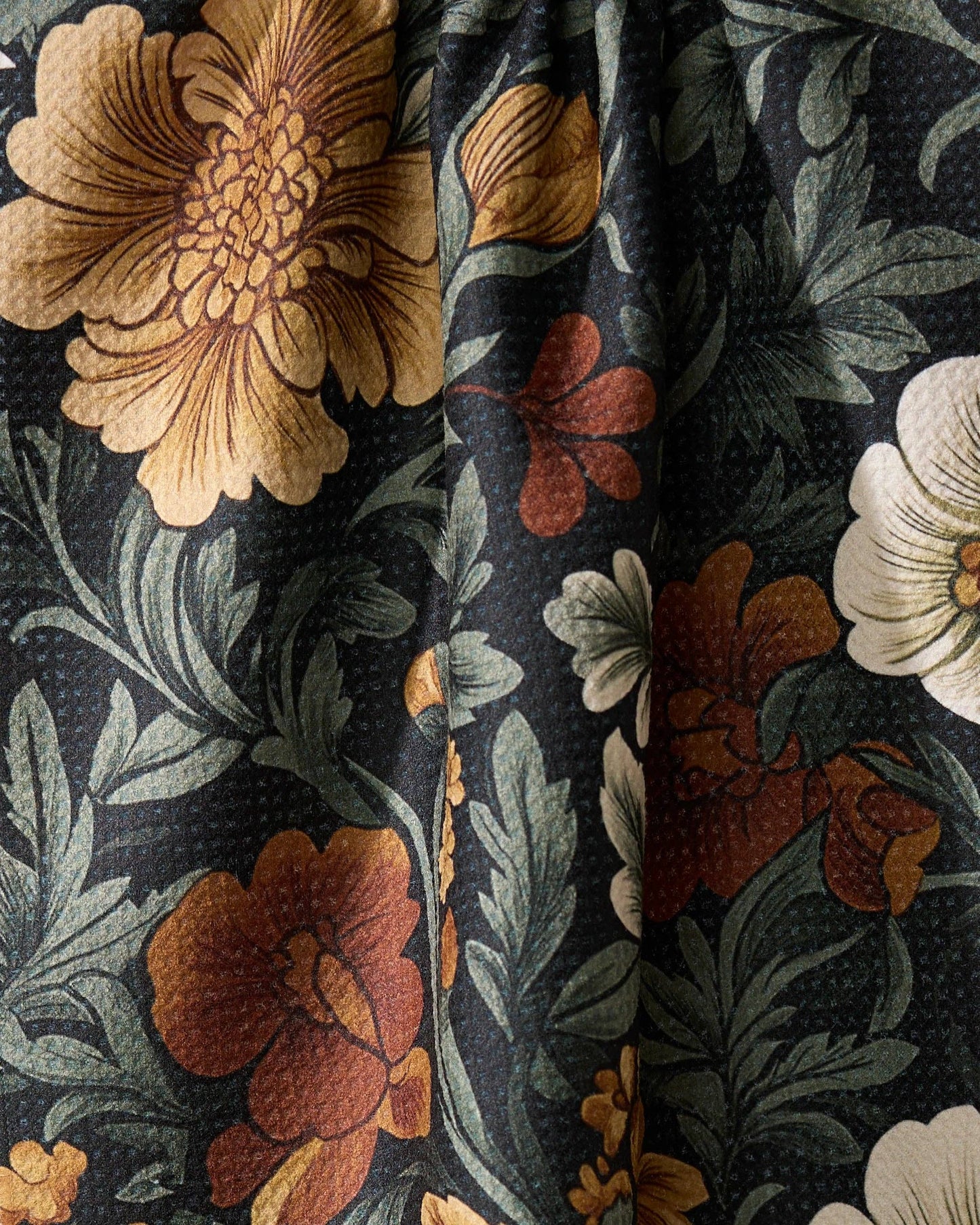 Close-up of floral kitchen tea towel with large flowers on a dark background Geometry brand