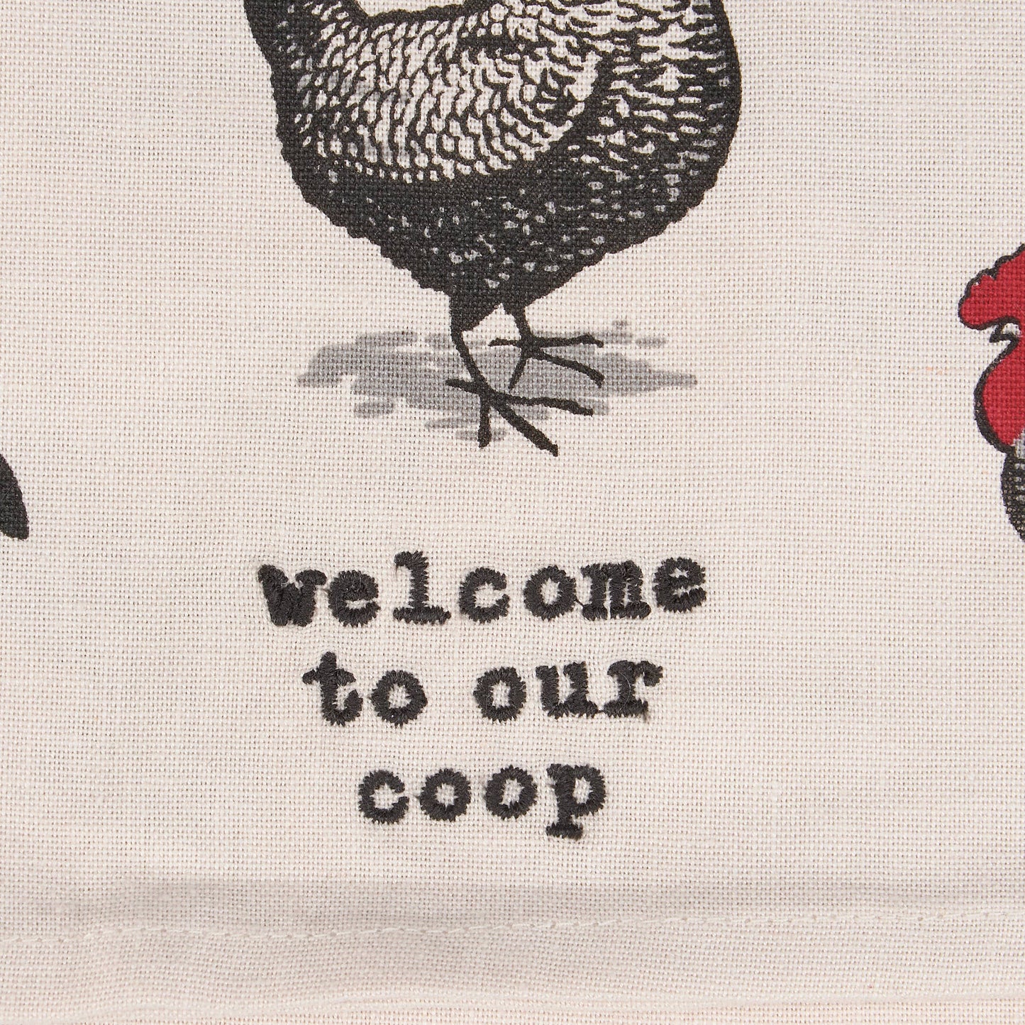 Textile with chicken illustrations and 'welcome to our coop' text on a neutral background