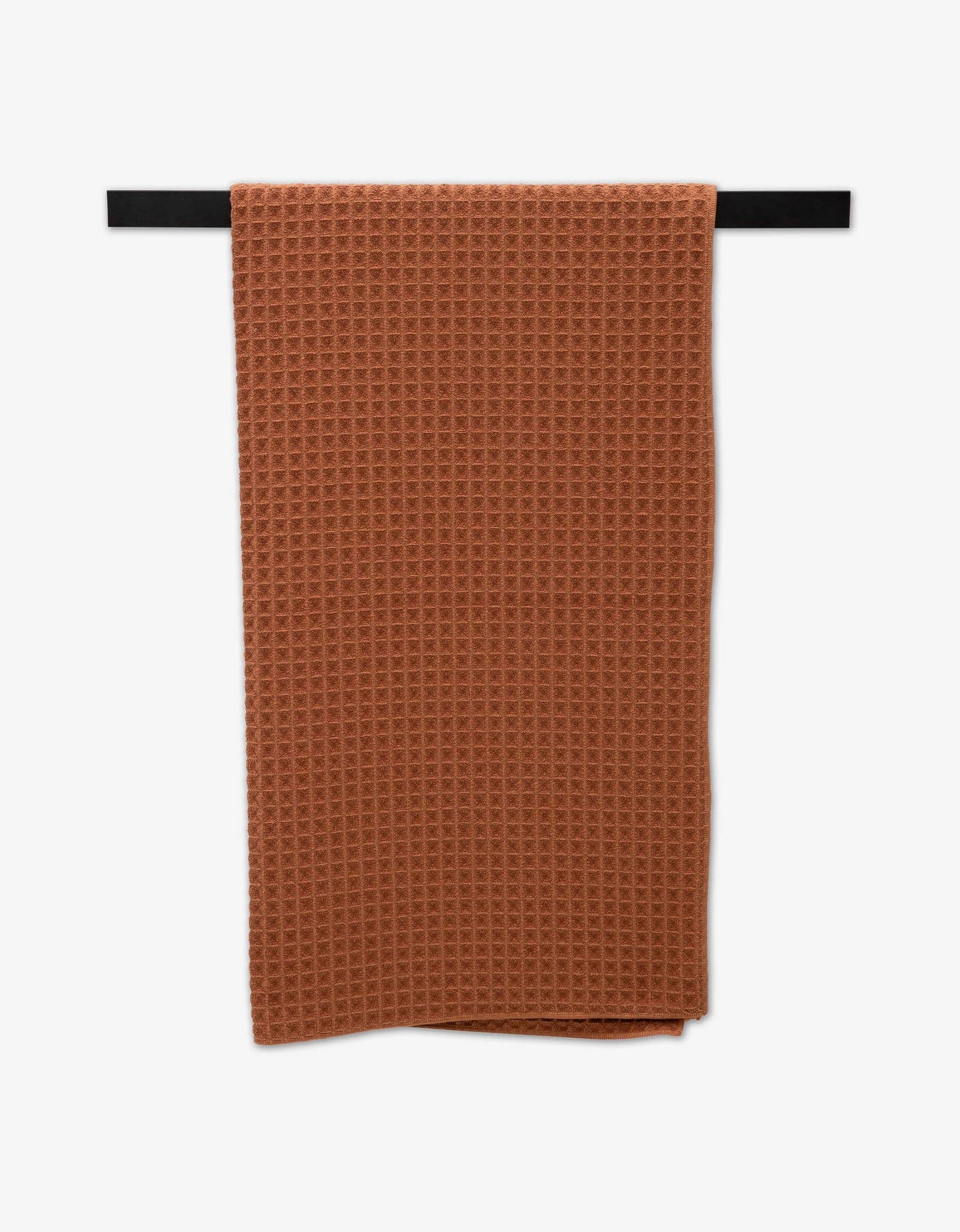 Geometry Waffle Bath Towel Clay hanging on a black rod against a white background