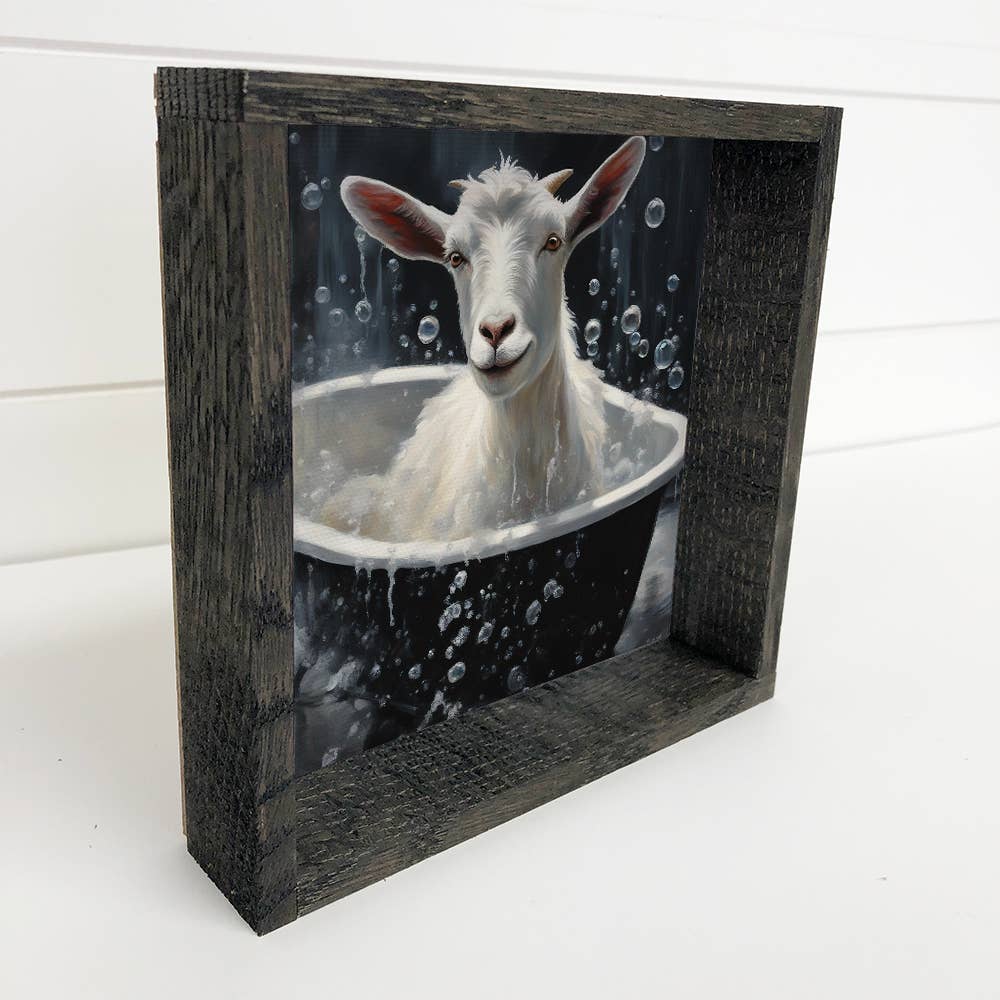 Framed artwork of a goat taking a bath with bubbles.