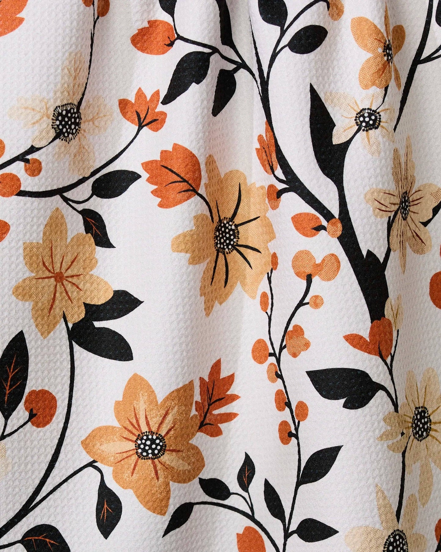 Geometry kitchen tea towel with floral pattern with orange, black, and beige flowers on a white background
