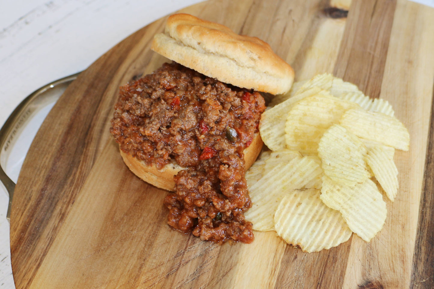 Sloppy joe and chips on a wooden board