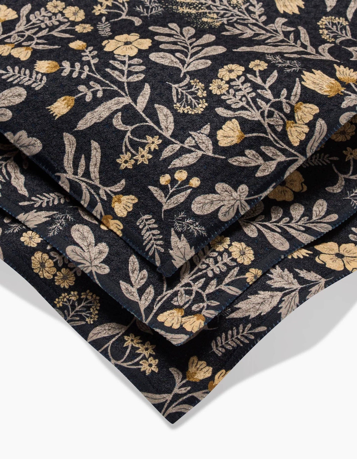 Floral patterned dishcloth fabric with gold and beige flowers on a dark background Geometry brand