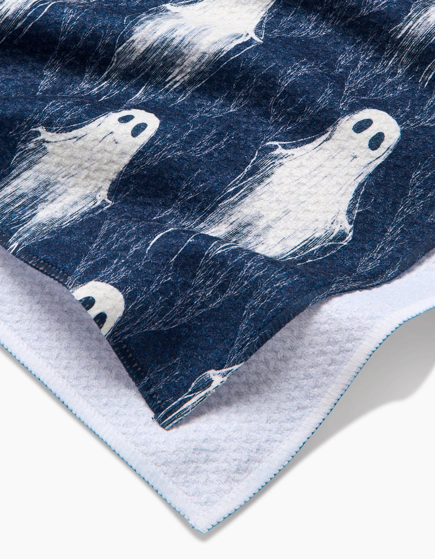 Navy blue towel with white ghost prints on a white background