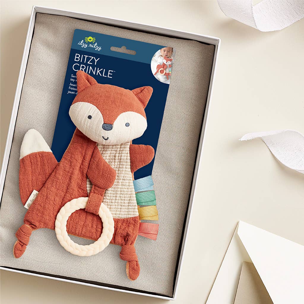 Fox-shaped baby rattle with crinkle element in packaging on a light background