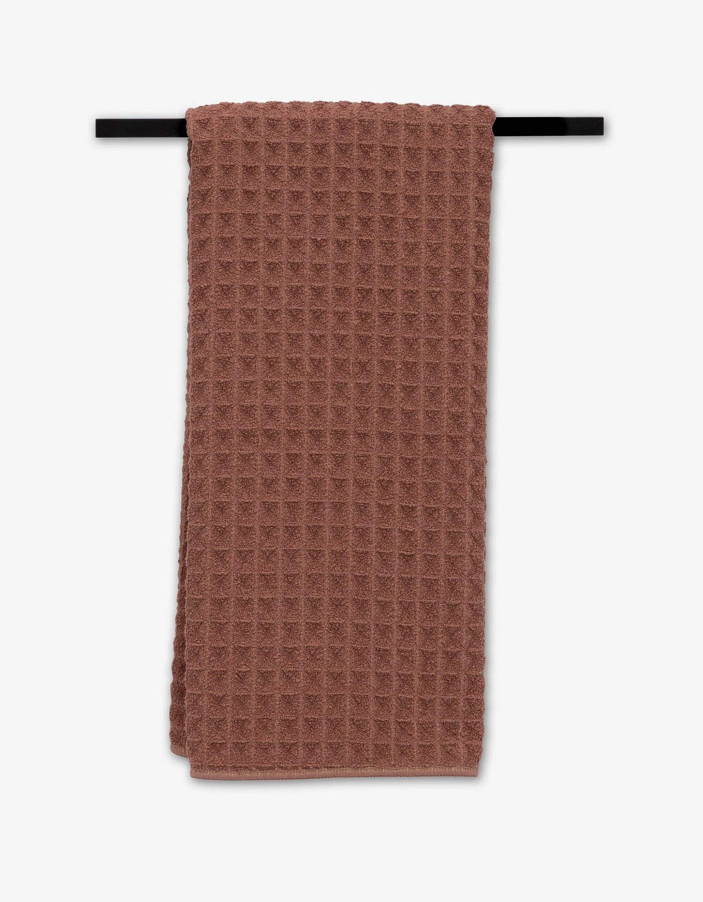 Geometry Waffle Hand Towel textured towel hanging on a black rod against a white background