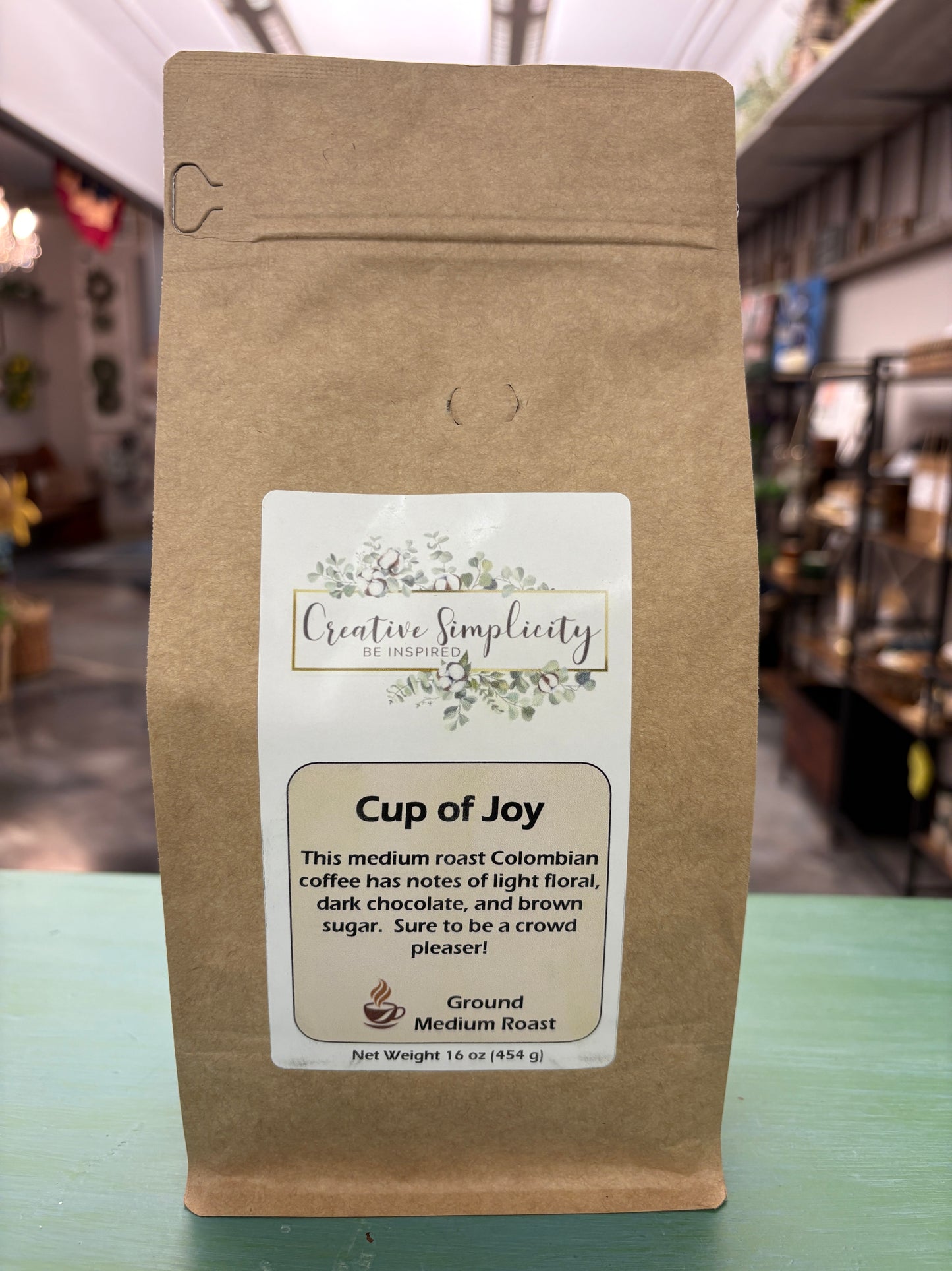 Coffee package with a Cup of Joy label on a blurred background