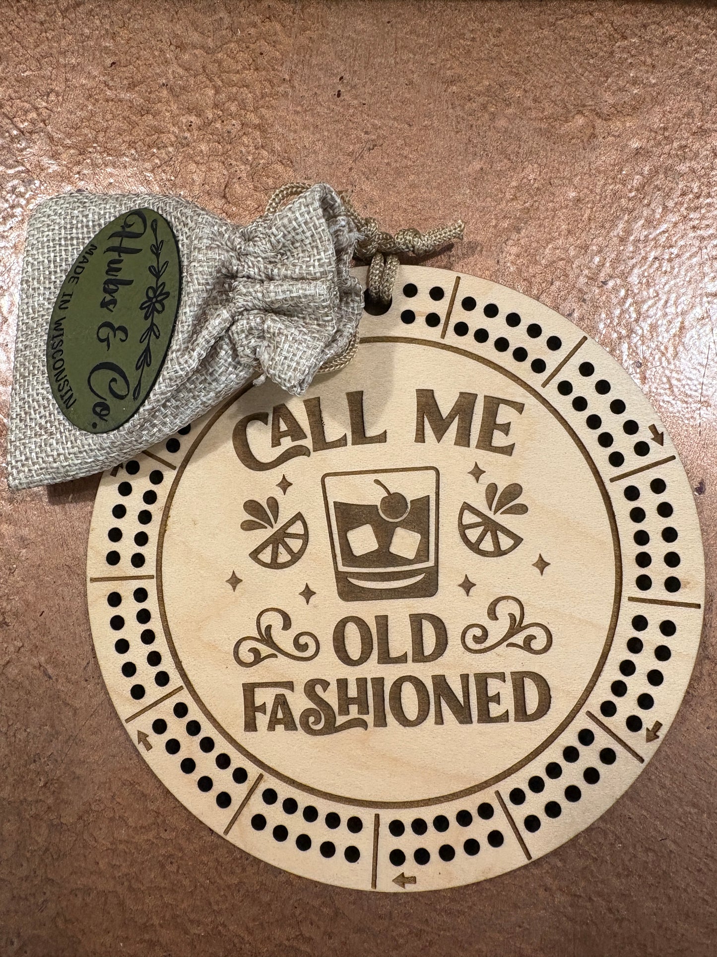 Round wooden coaster with 'Call Me Old Fashioned' design and a small drawstring bag labeled 'Hubs & Co'.