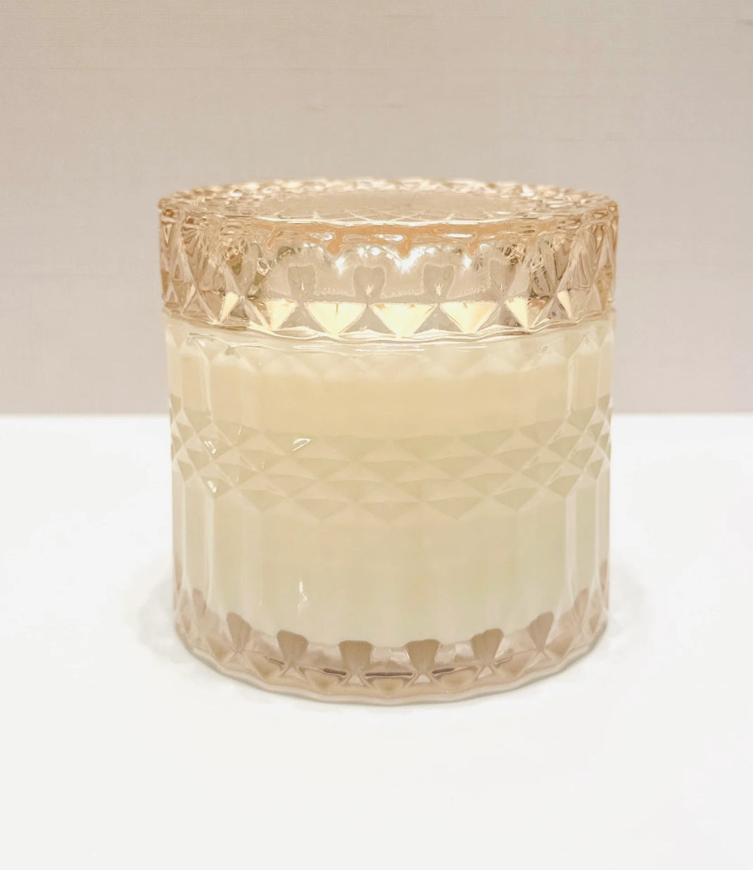 Decorative glass candle holder with a textured design on a white background