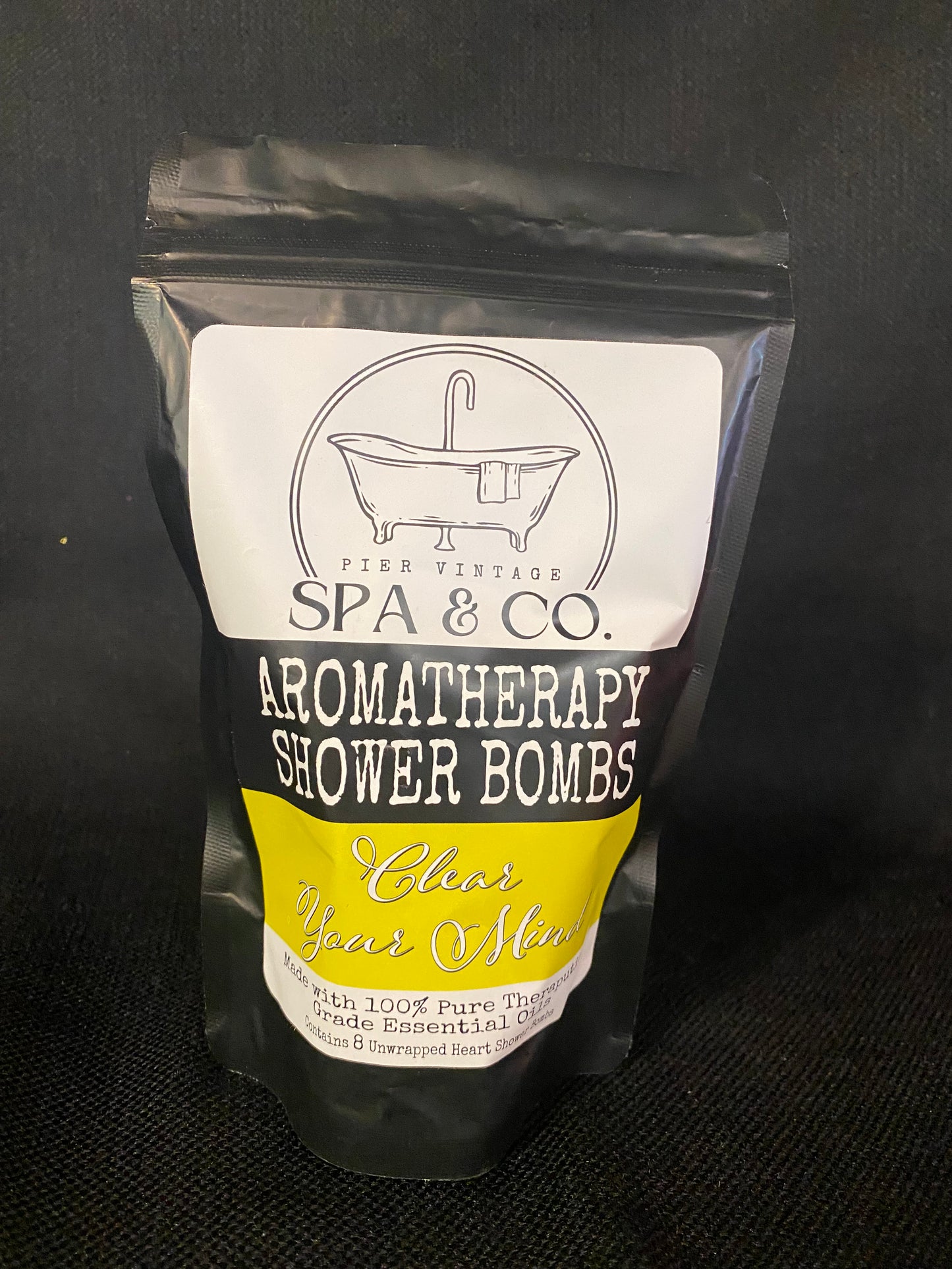 Packaged aromatherapy shower bomb with Pier Vintage Spa & Co branding on a dark background