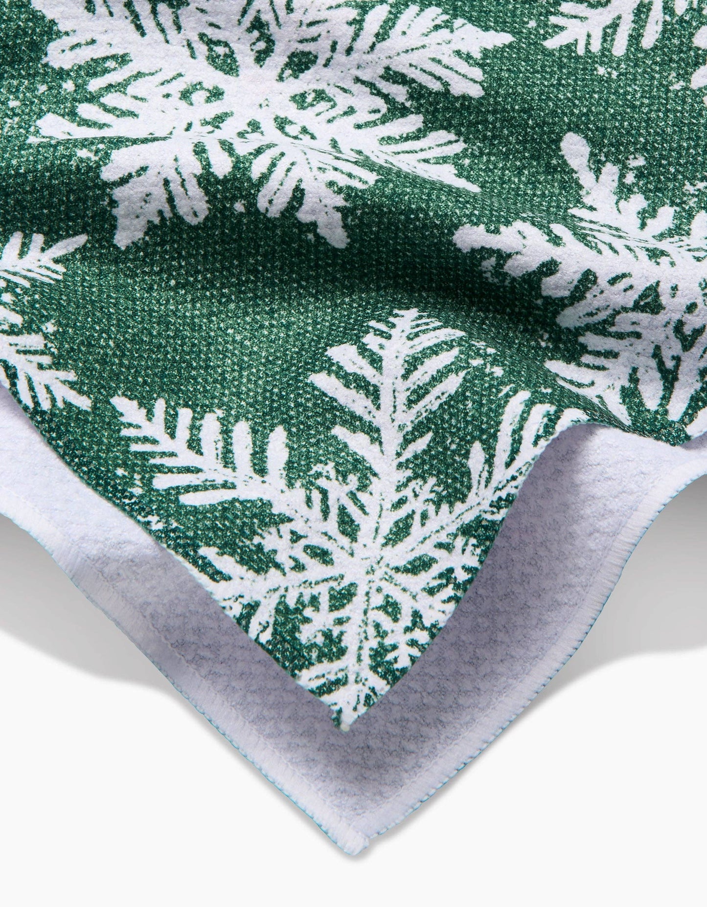 Green fabric with white snowflake pattern on a white background