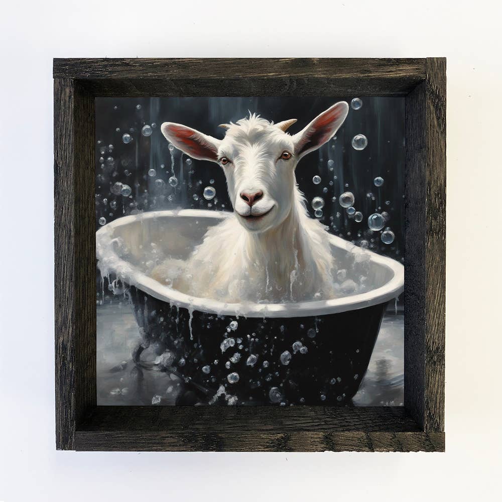 Framed artwork of a goat taking a bath with bubbles.