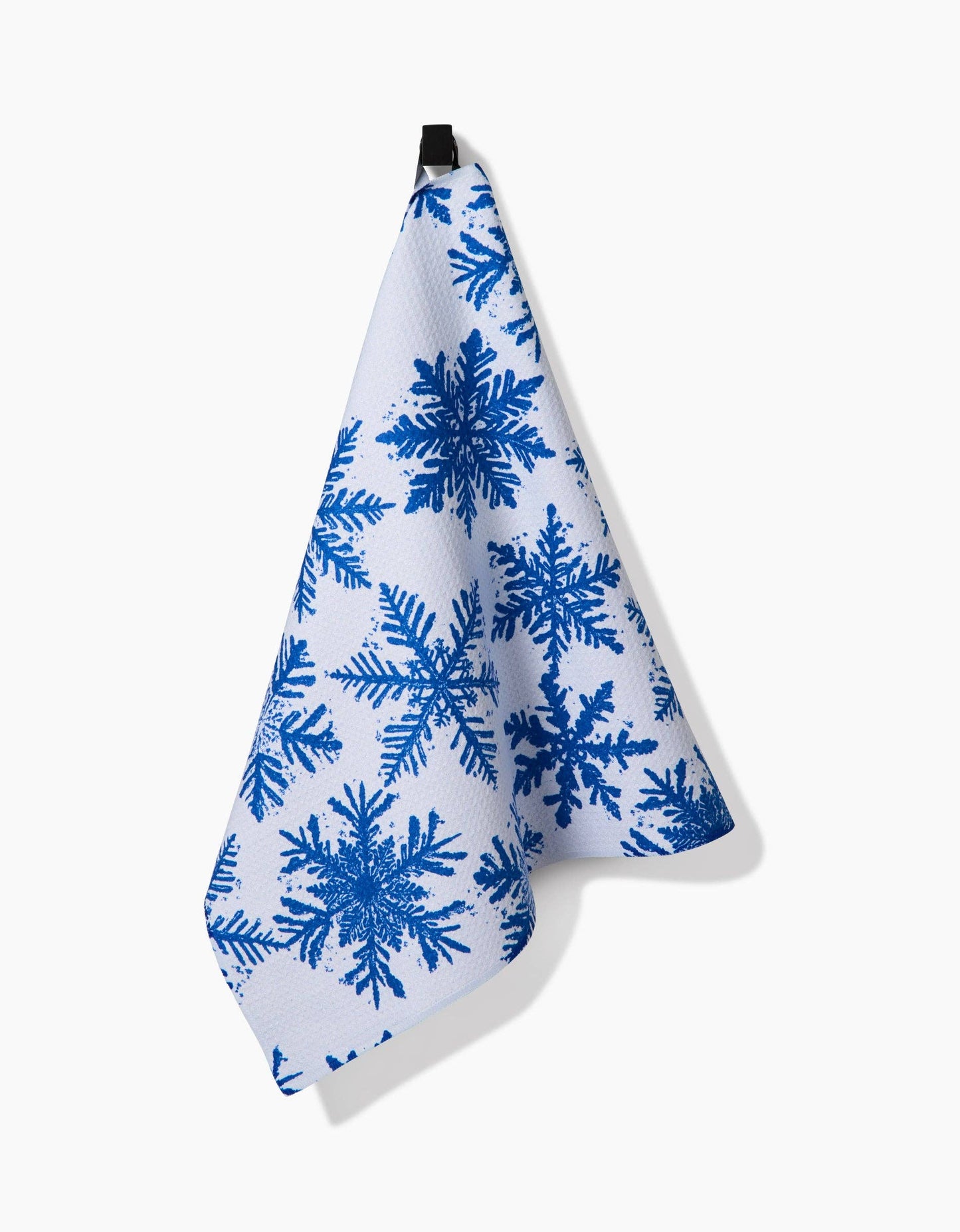 White towel with blue snowflake pattern hanging on a white background
