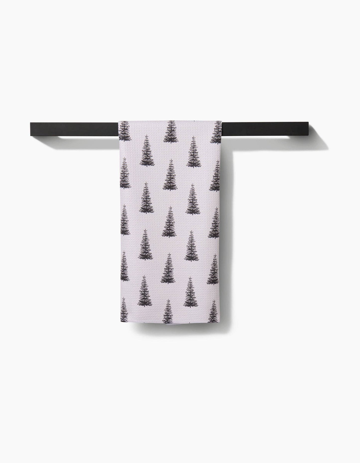 Geometry Tea Towel Alpine Forest Towel with tree pattern hanging on a black rack against a white background