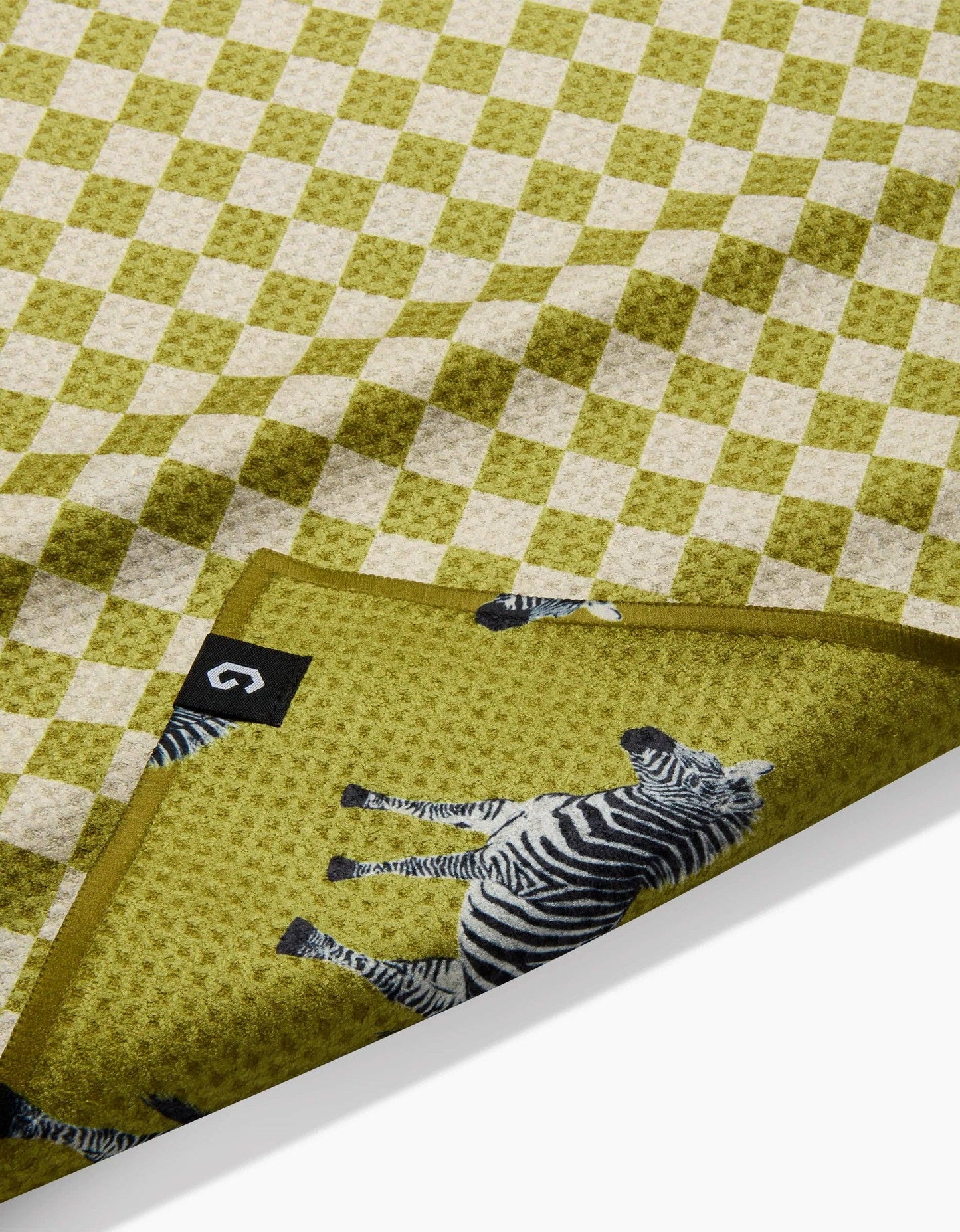 Green checkered fabric with zebra design and a visible brand logo.