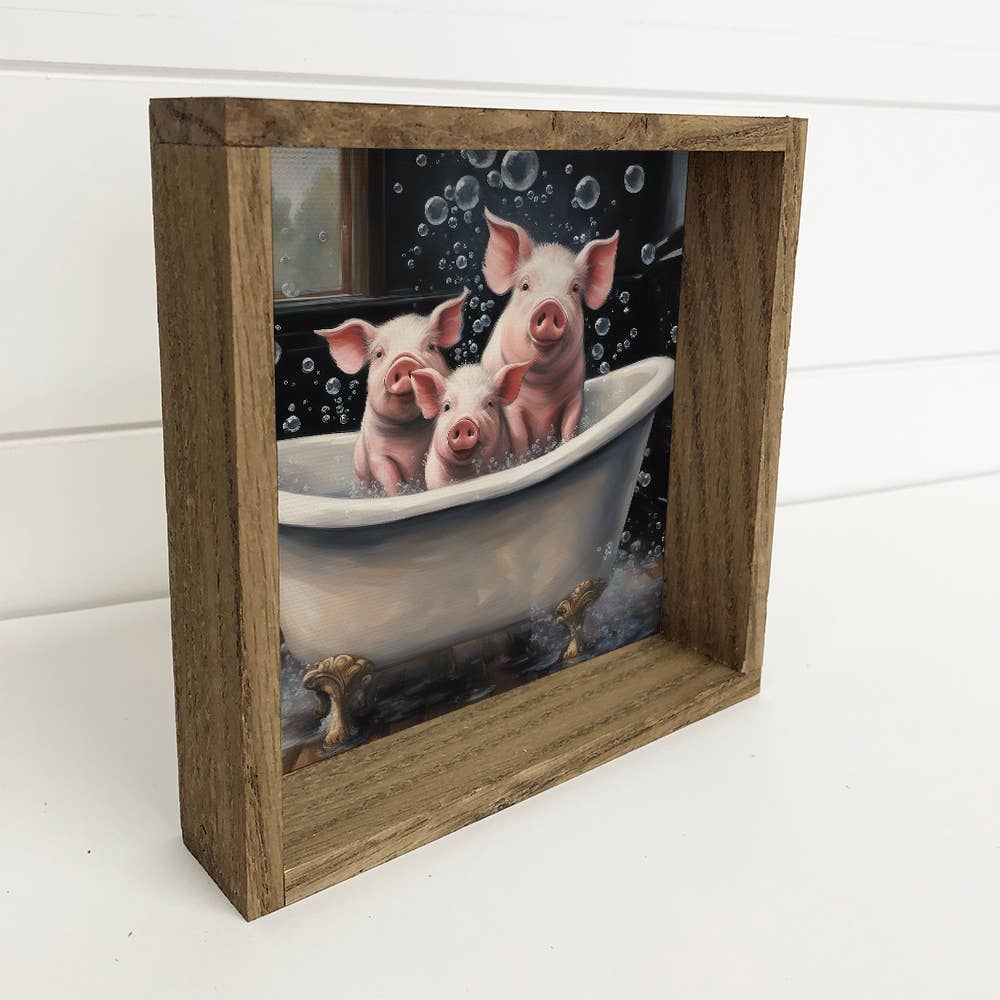 Framed artwork of three pigs in a bathtub with bubbles.