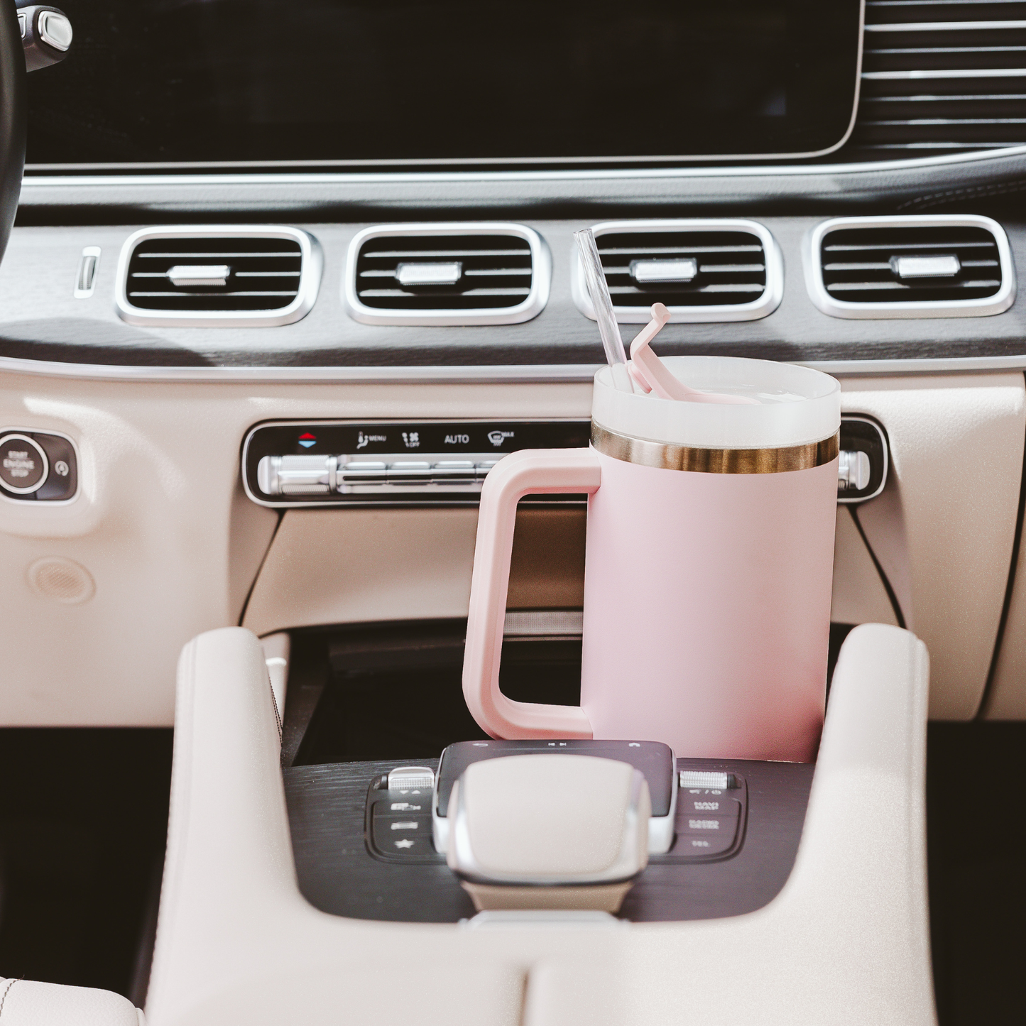 Pink mug with straw in a car cup holder
