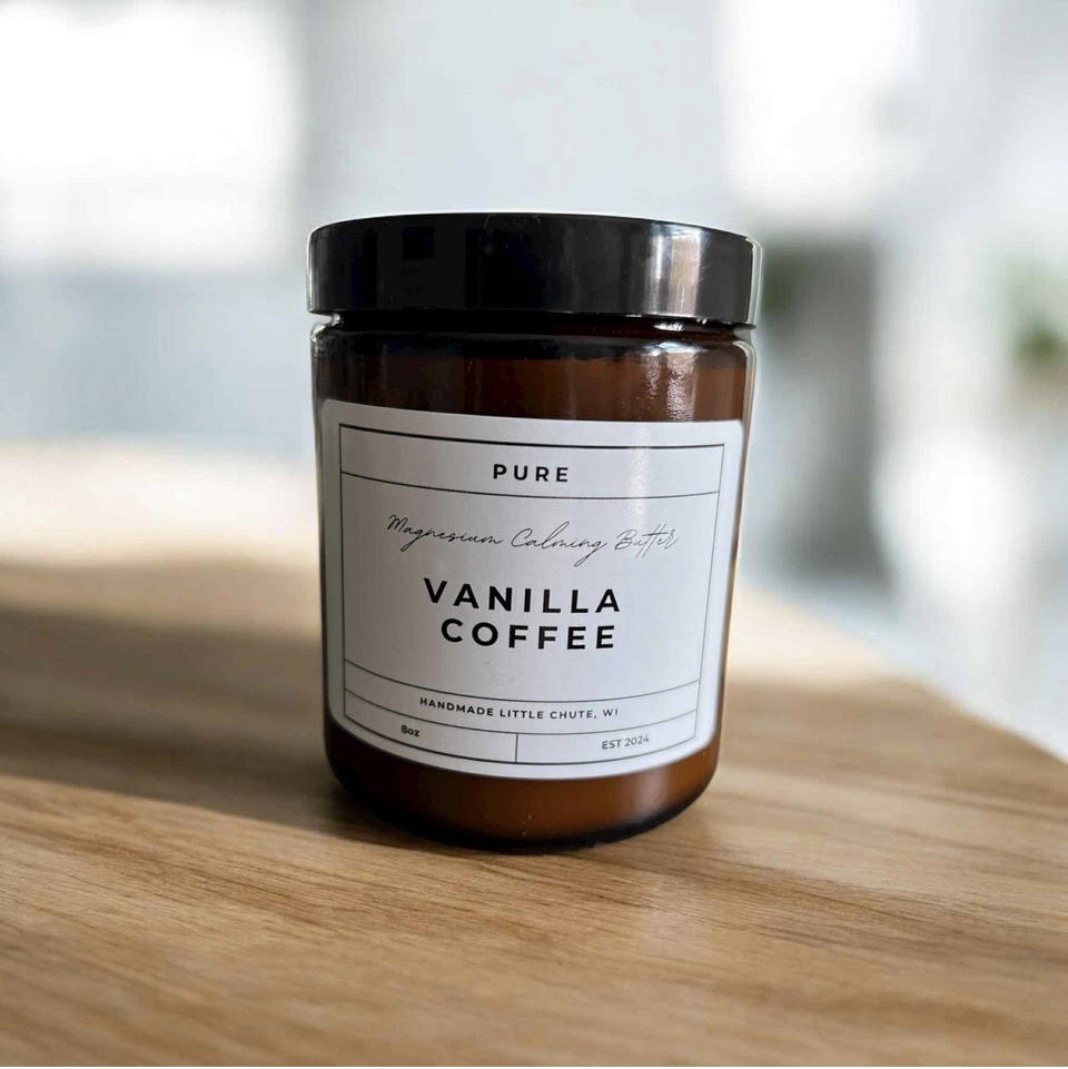 Vanilla coffee magnesium calming butter jar on a wooden surface with a blurred background