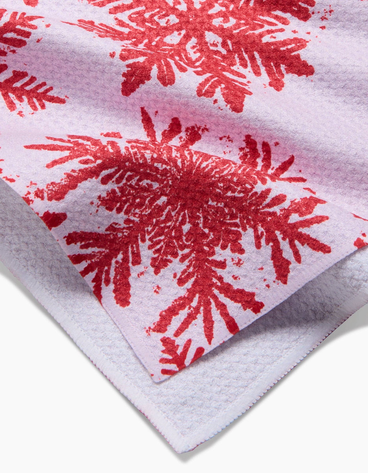 White towel with red snowflakes pattern on a white background