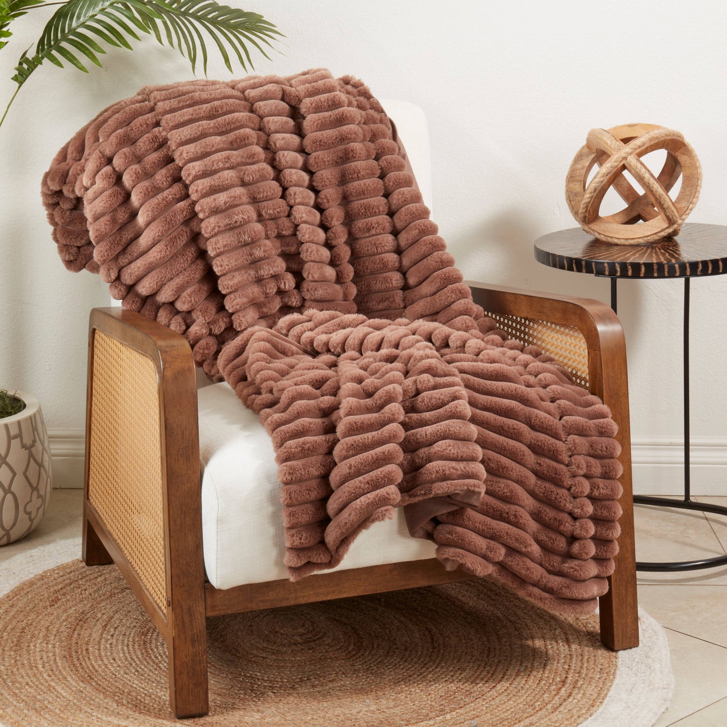 Brown textured Faux Rabbit blanket draped over a wooden chair in a cozy room setting.