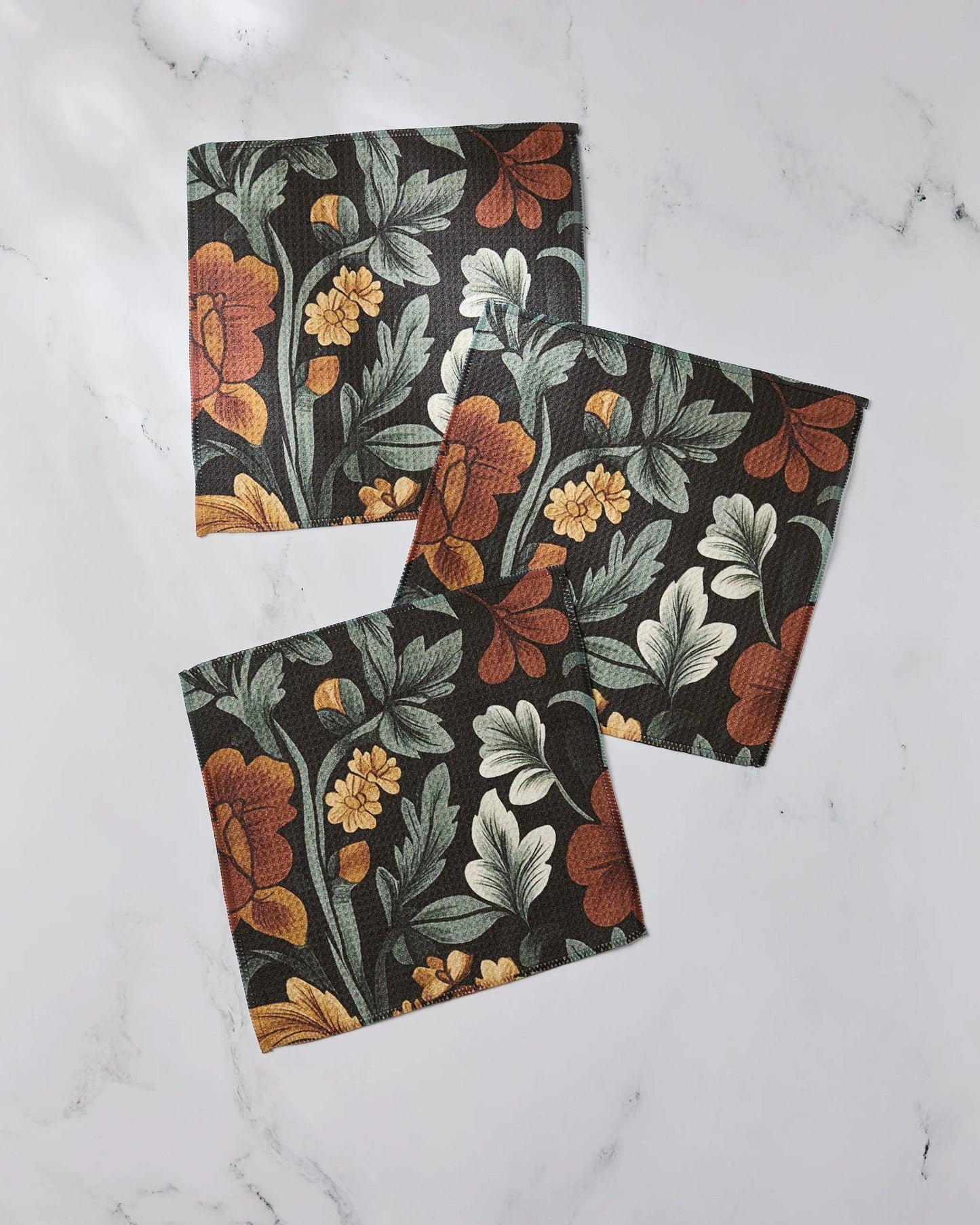 Set of three Geometry dishcloths with floral-patterned on a white marble surface