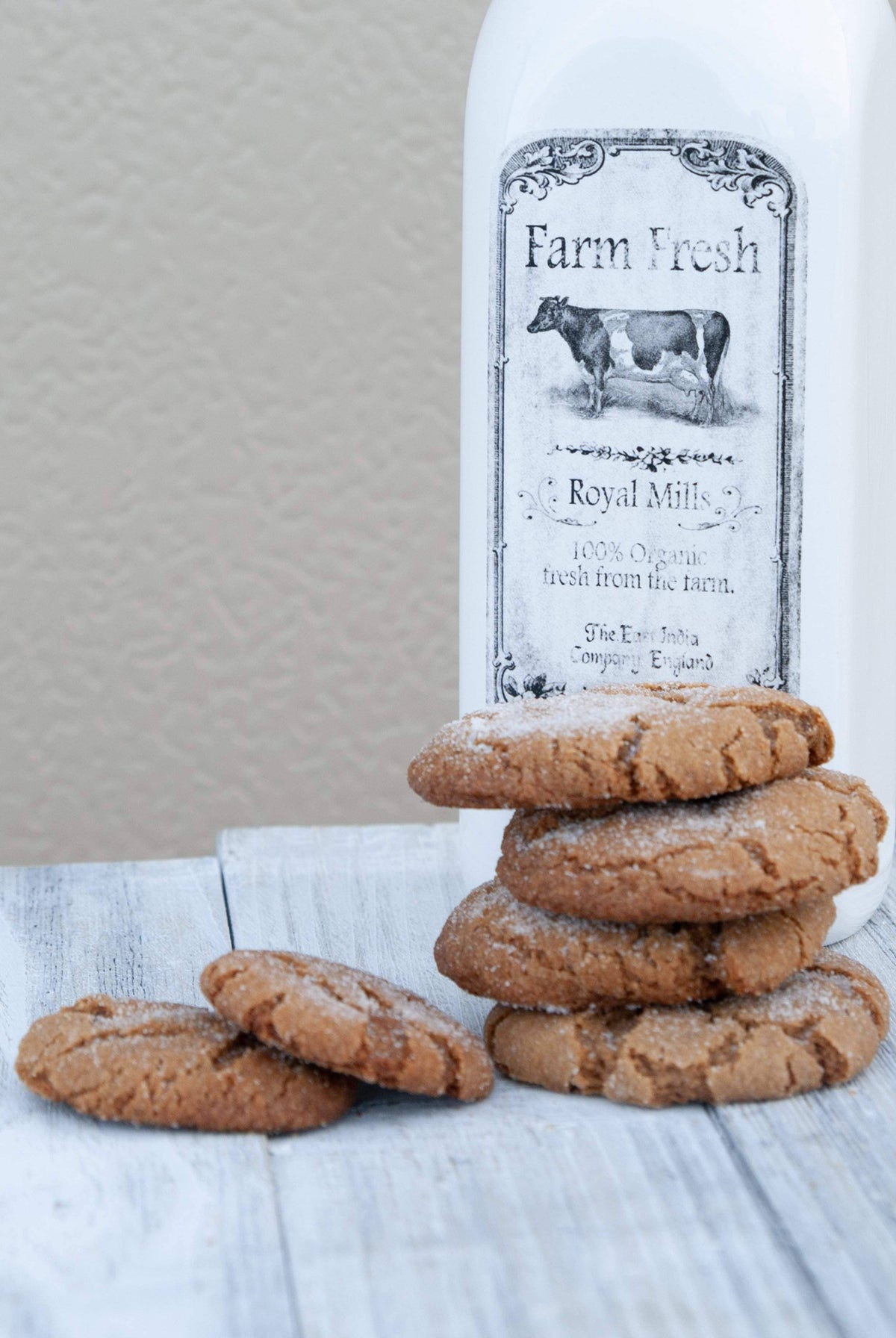 Stack of cookies in front of a bottle labeled 'Farm Fresh Royal Mills'.