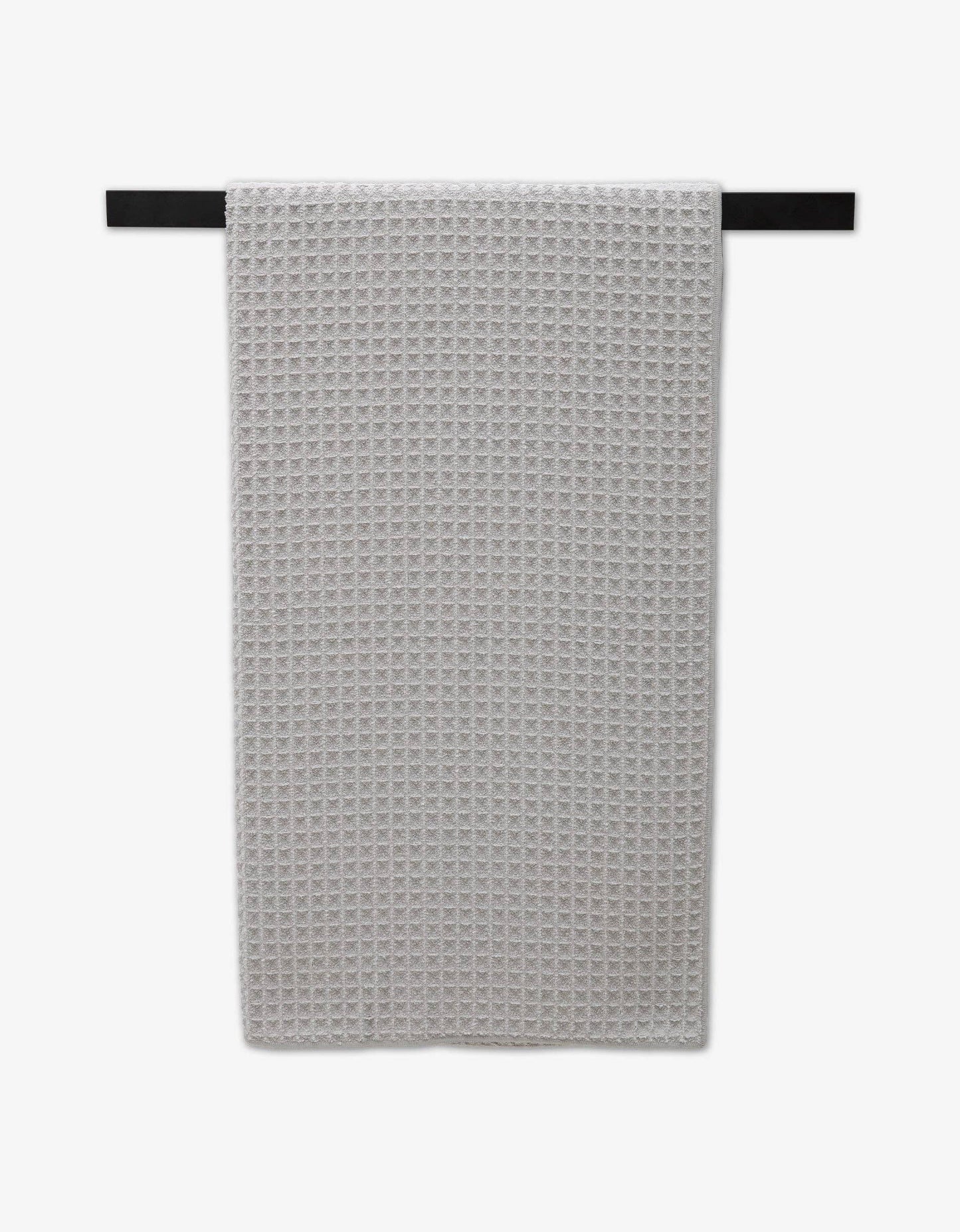 Geometry Waffle Bath Towel Stone hanging on a black bar with white background