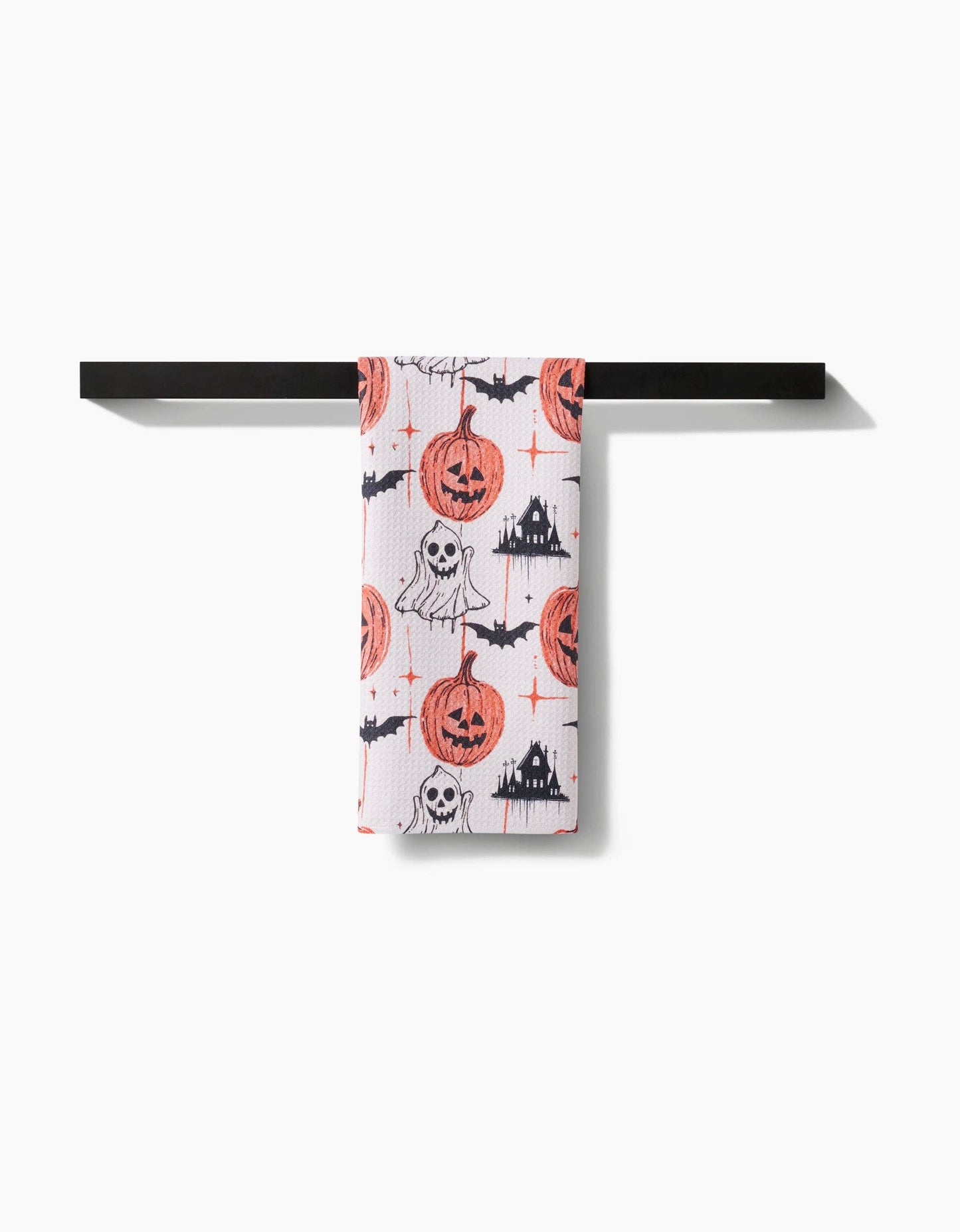 Halloween-themed towel hanging on a black rack against a white background