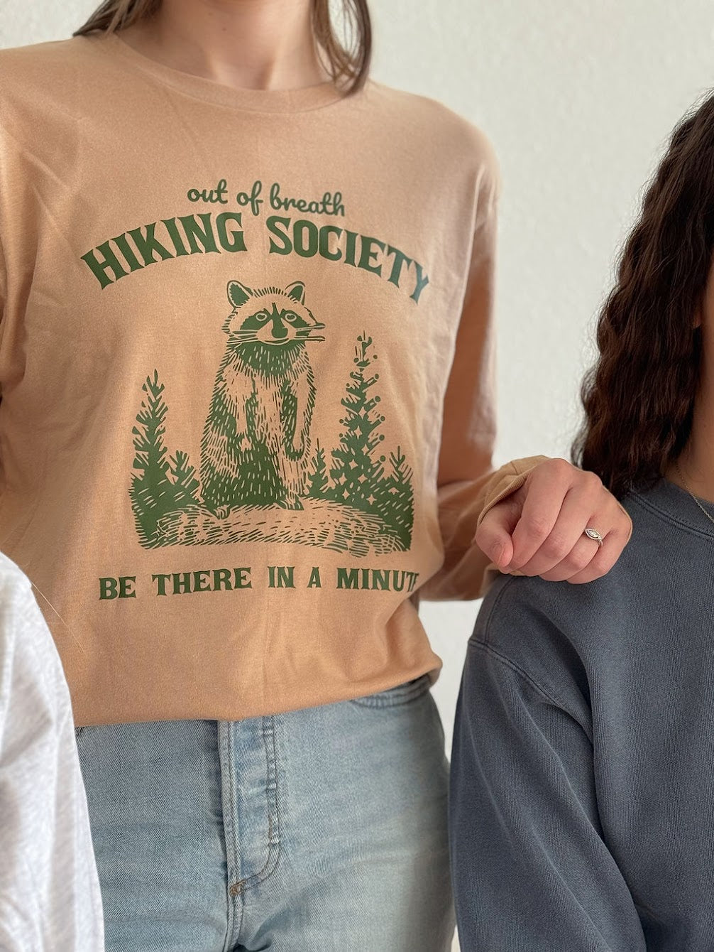 Long sleeve sand colored long sleeve top with out of breath hiking society raccoon image