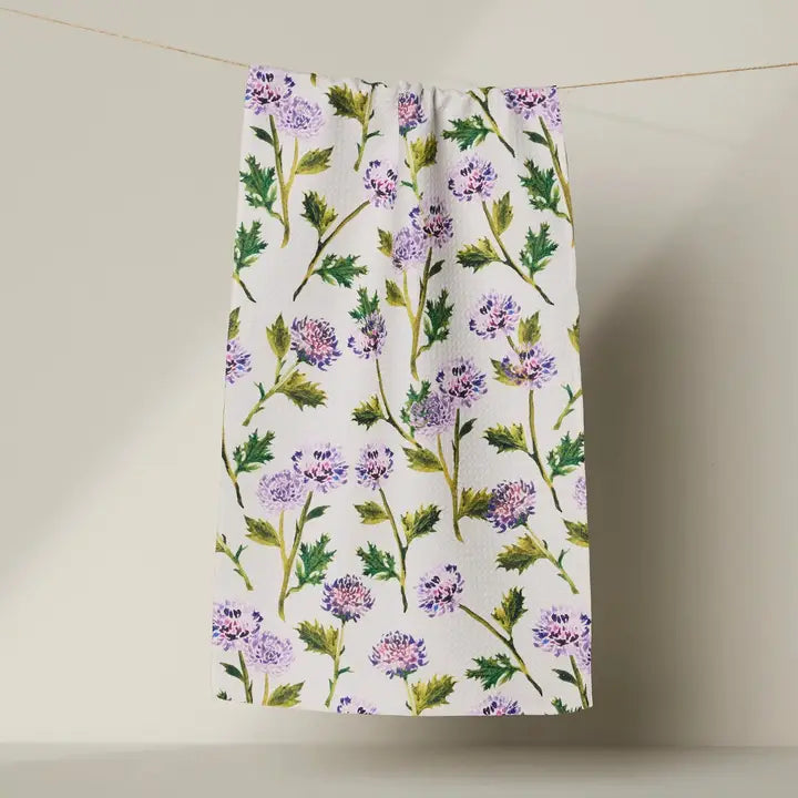 Floral patterned Geometry bar towel hanging on a line against a neutral background