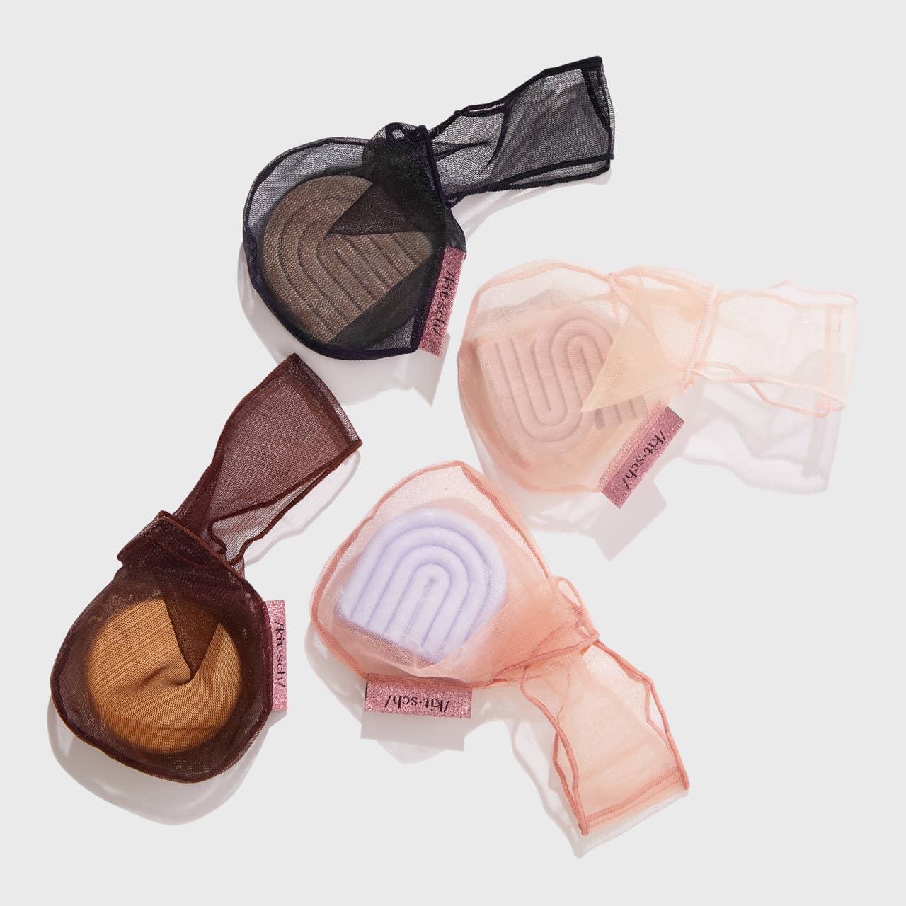A blush pink mesh fabric shampoo beauty bar bag with a transparent window displaying the product. It is packaged with a product card that has text including the brand name and product description.