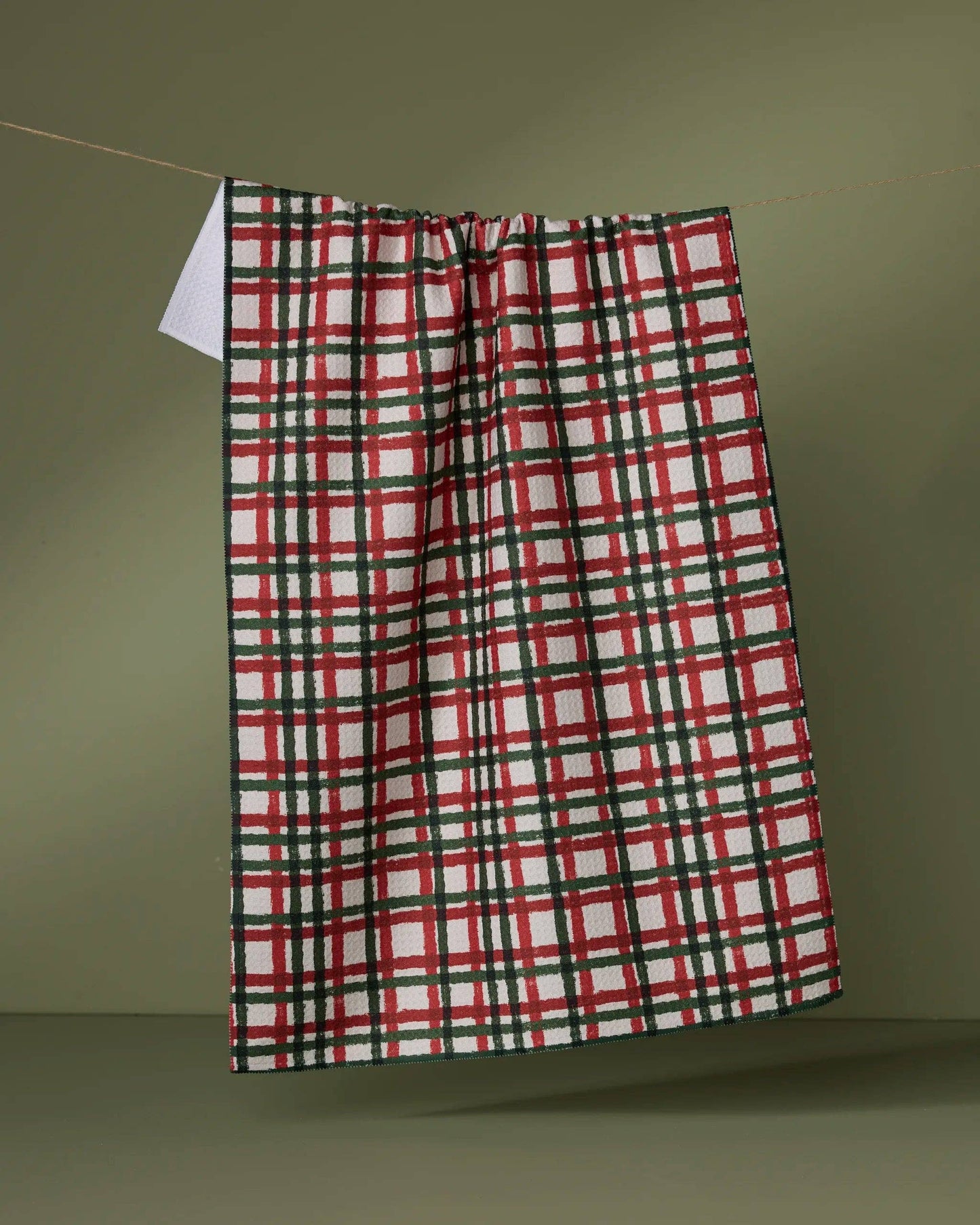 Geometry Tea Towel Plaid towel hanging on a line against a green background