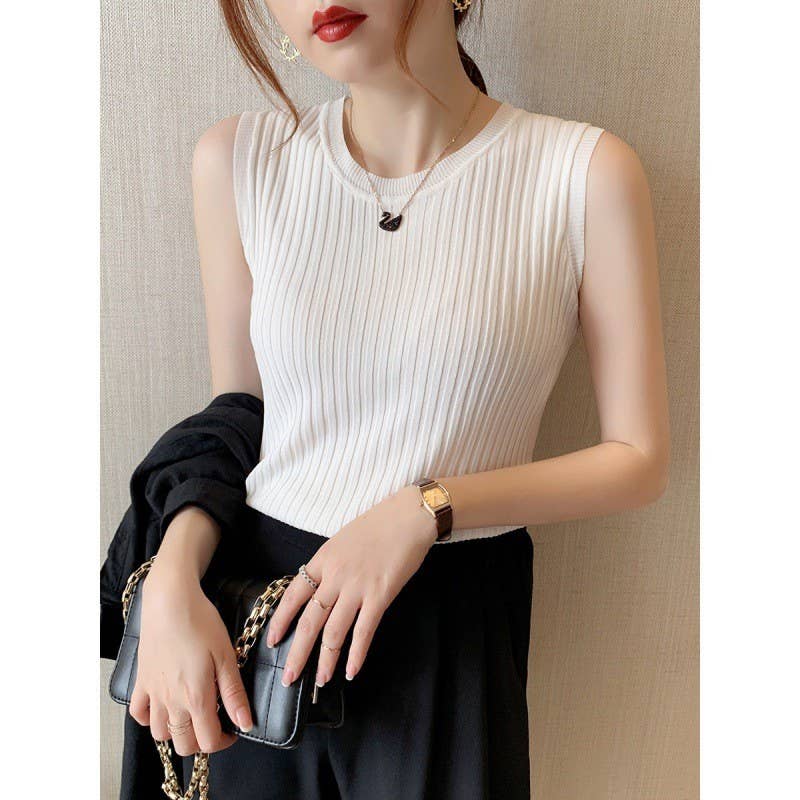 Woman wearing a white sleeveless top and black skirt, holding a clutch.