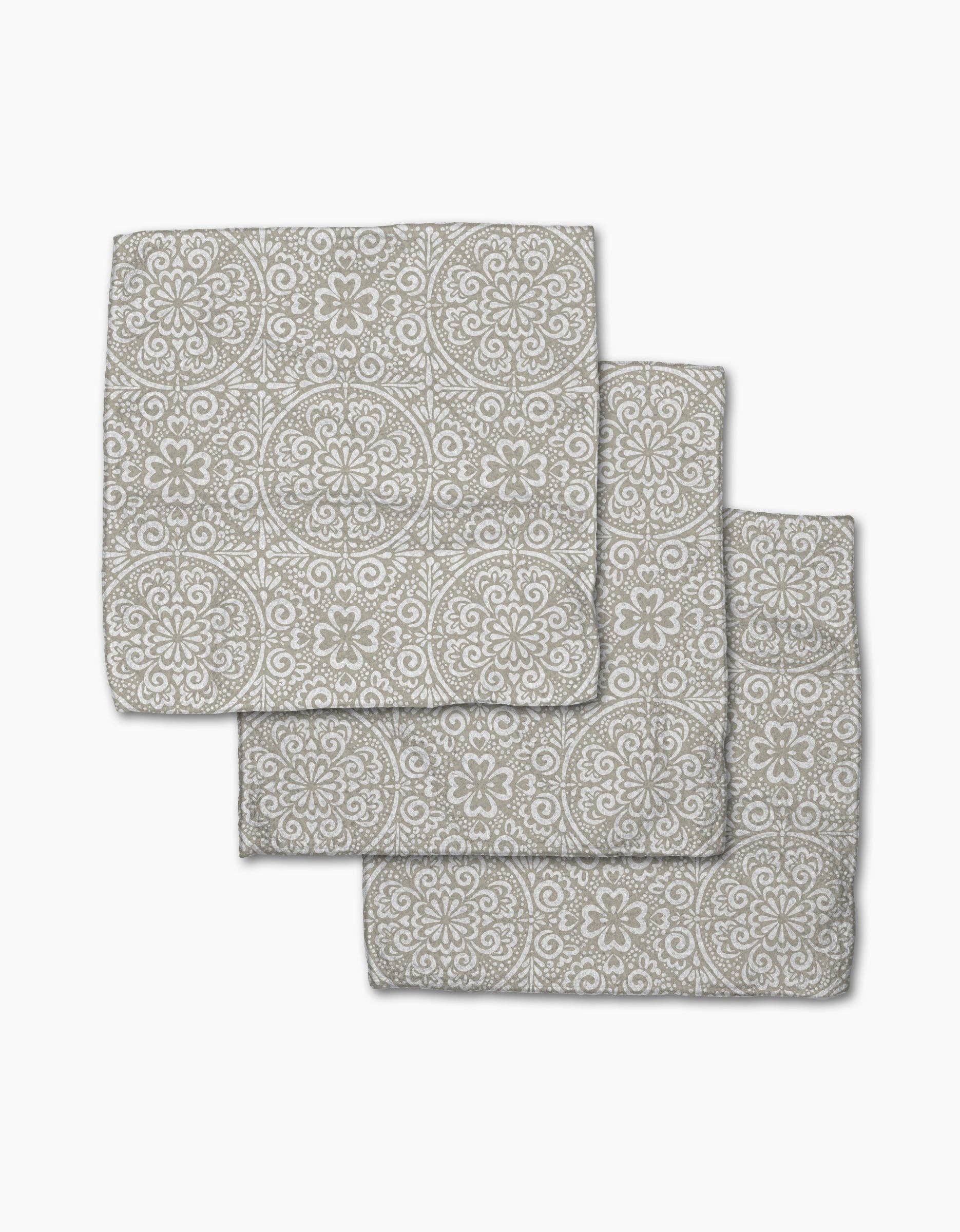 Set of three gray patterned bath mats on a white background