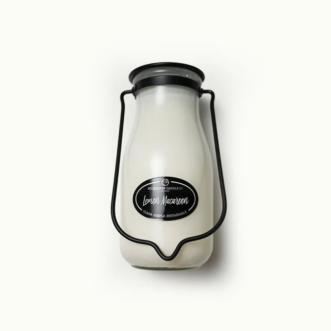 Candle in a glass jar with a black lid and label on a white background