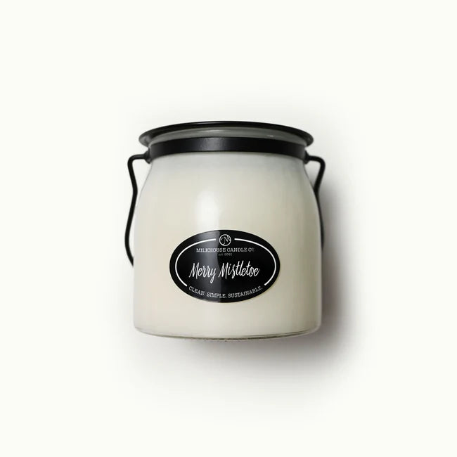 White candle jar with black lid and label on a white background