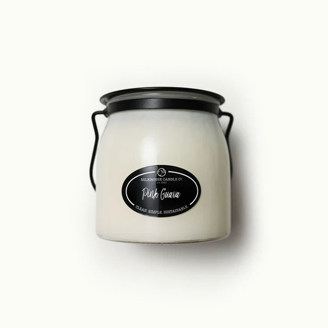 White candle jar with black lid and label on a white background