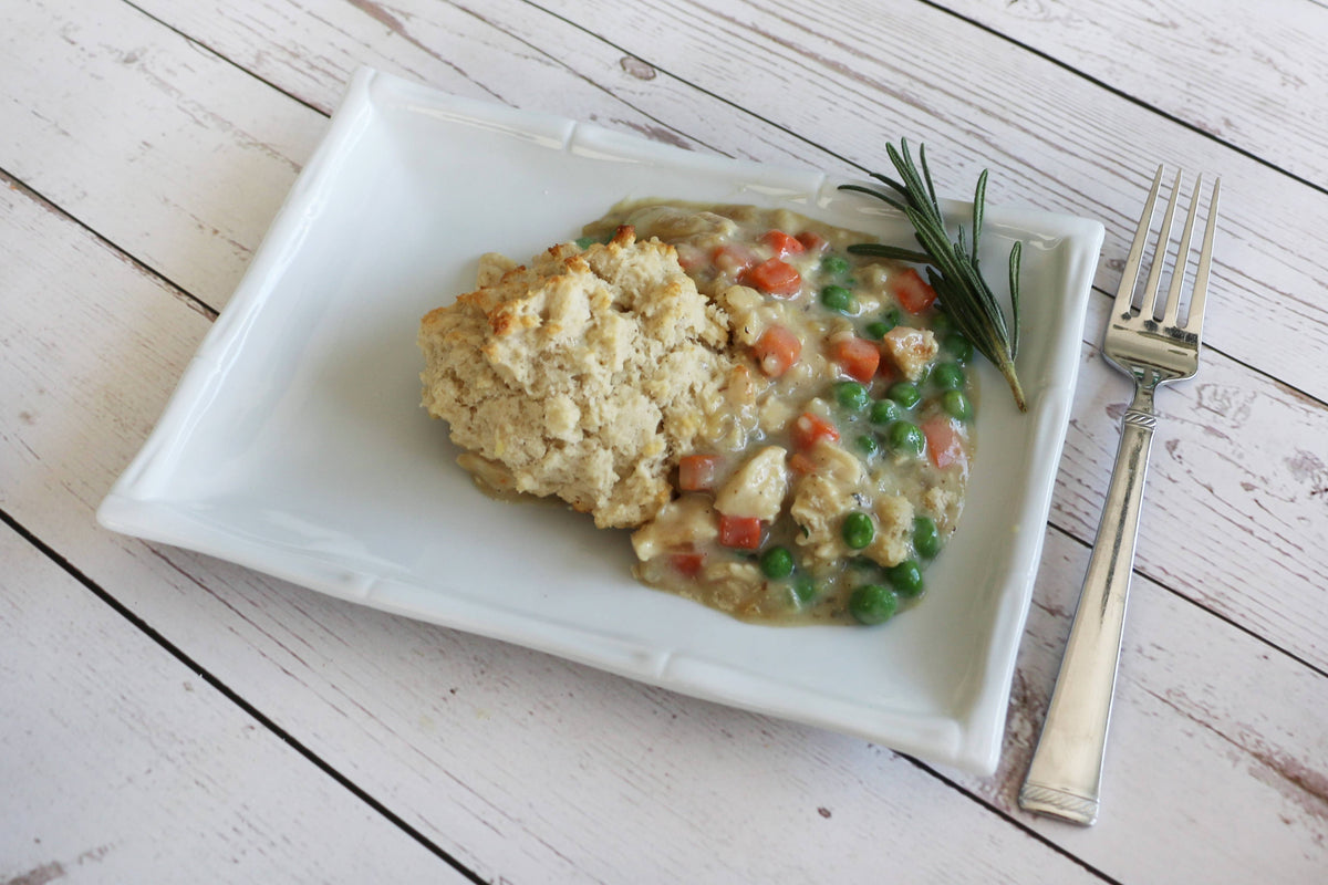 Plate of food with a biscuit on a wooden table