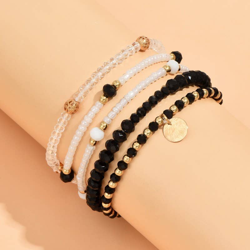 Set of beaded bracelets with gold accents on a beige background
