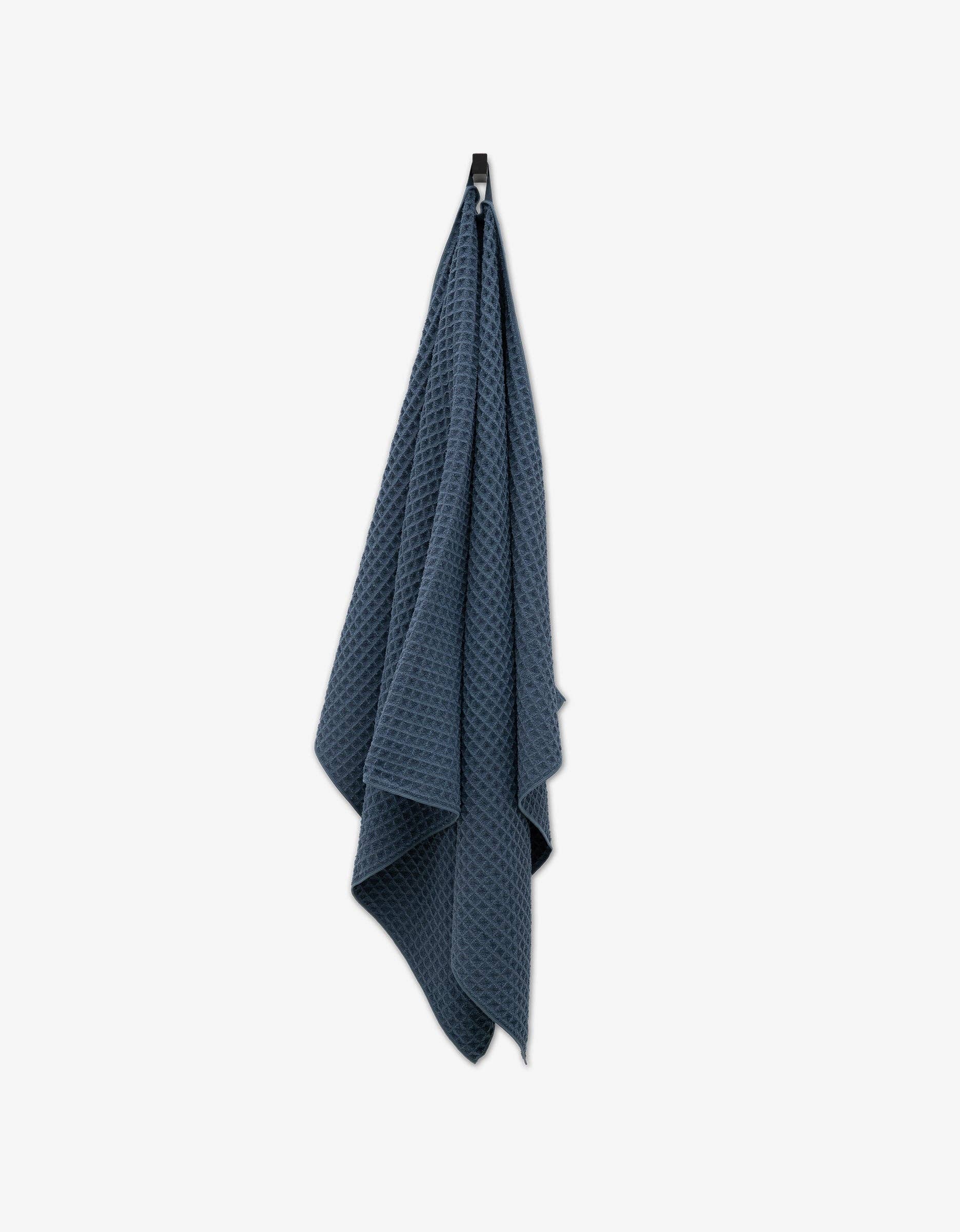 Geometry Waffle Bath Towel Midnight Blue textured towel hanging on a white background