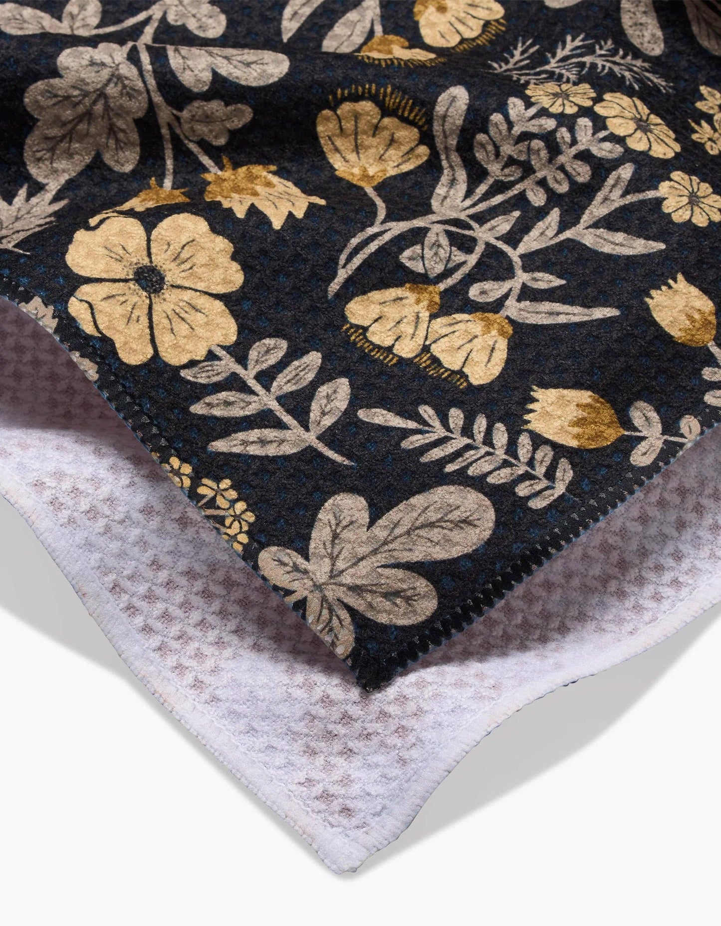 Geometry kitchen tea towel with floral patterned fabric on a black background