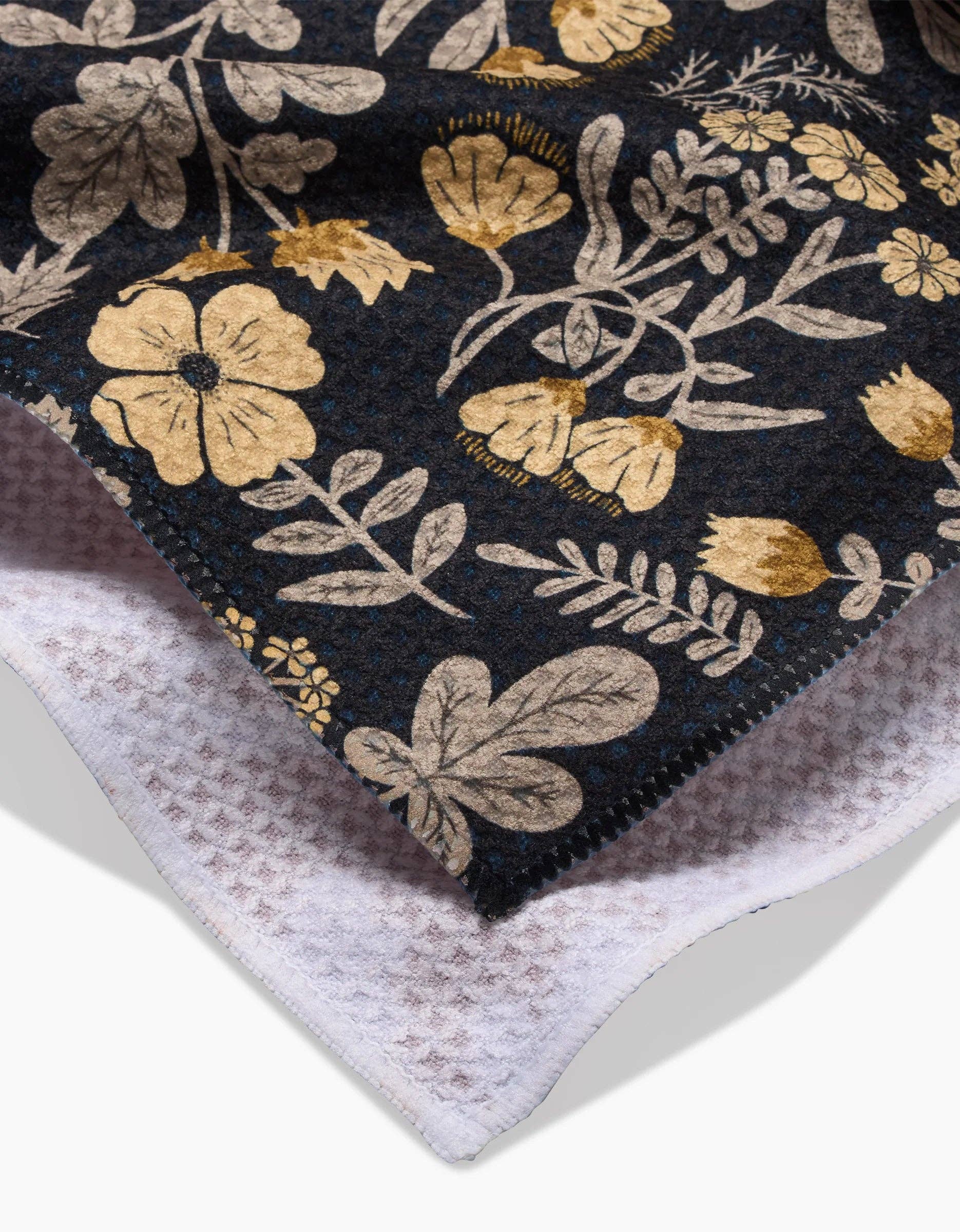 Geometry kitchen tea towel with floral patterned fabric on a black background
