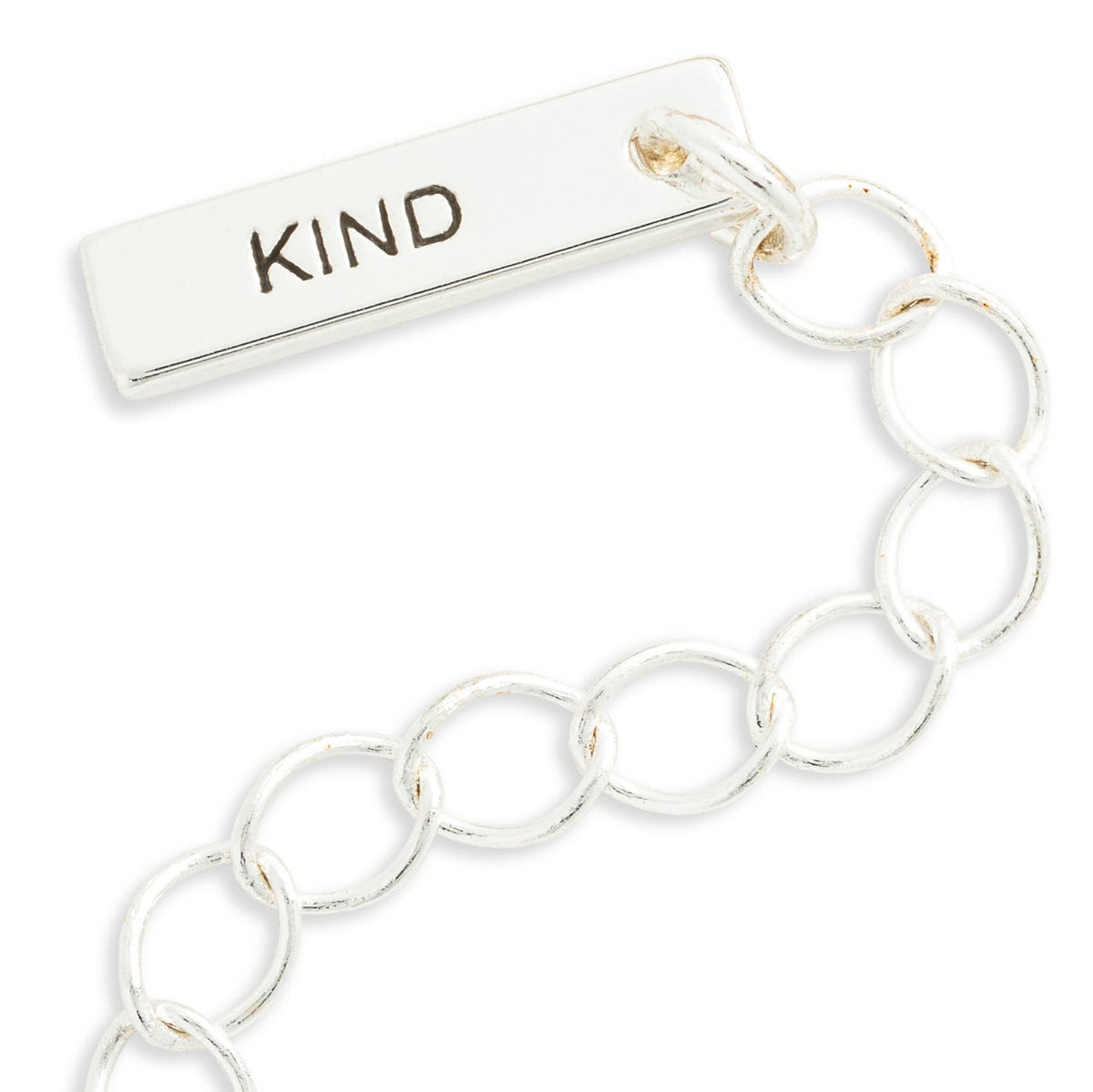 A silver-toned bar link charm featuring a rectangular bar engraved with the word 'KIND' in dark lettering, connected to a series of interlocking circular links on a white background.