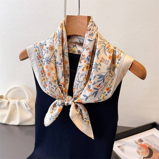 Floral scarf draped over a black garment on a wooden hanger against a white background.