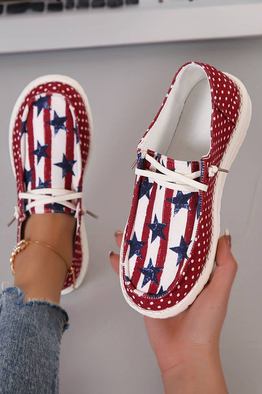 Red, white, and blue star-patterned shoes held by a person with a neutral background