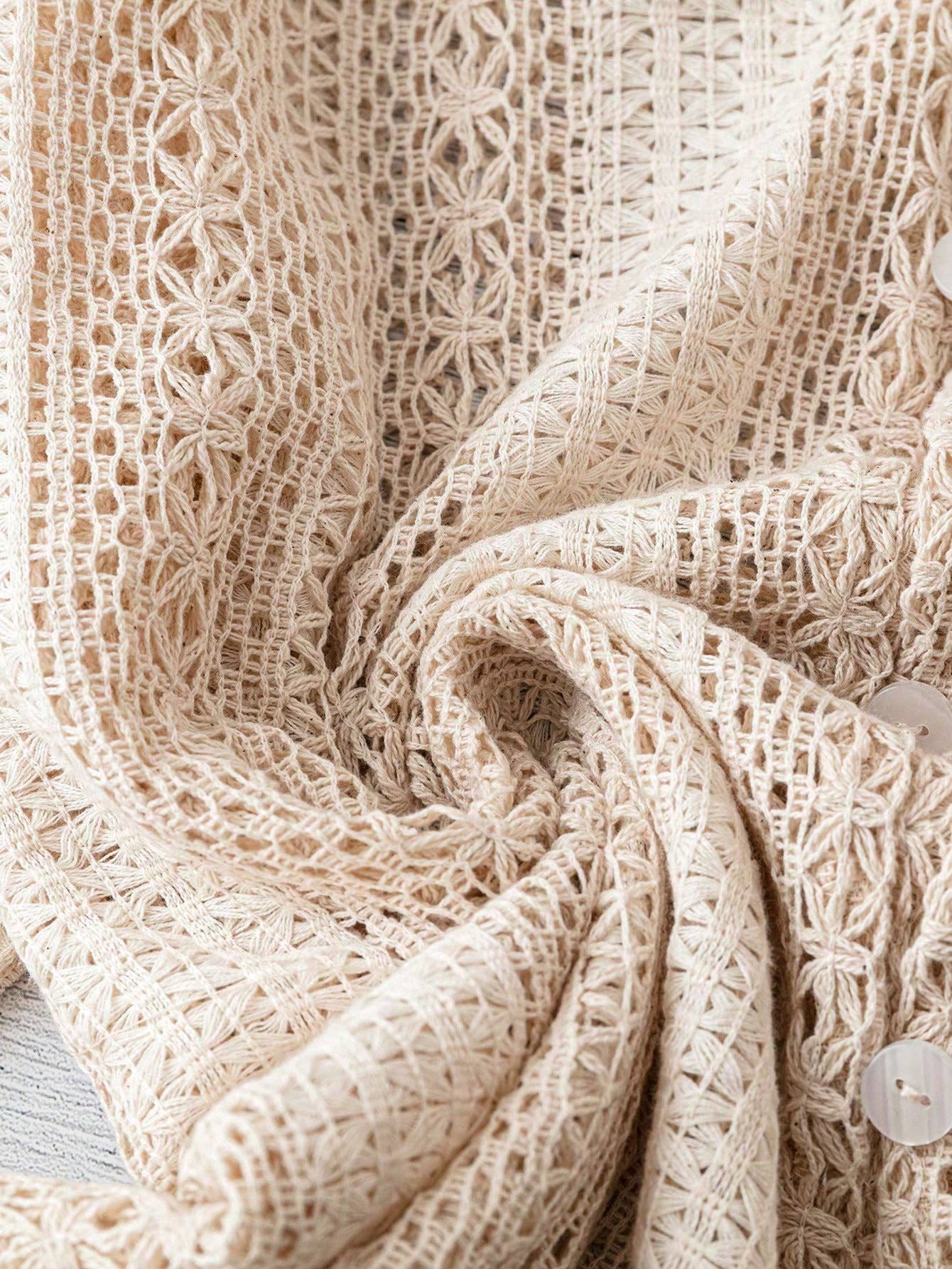 Close-up of beige crochet fabric with intricate patterns